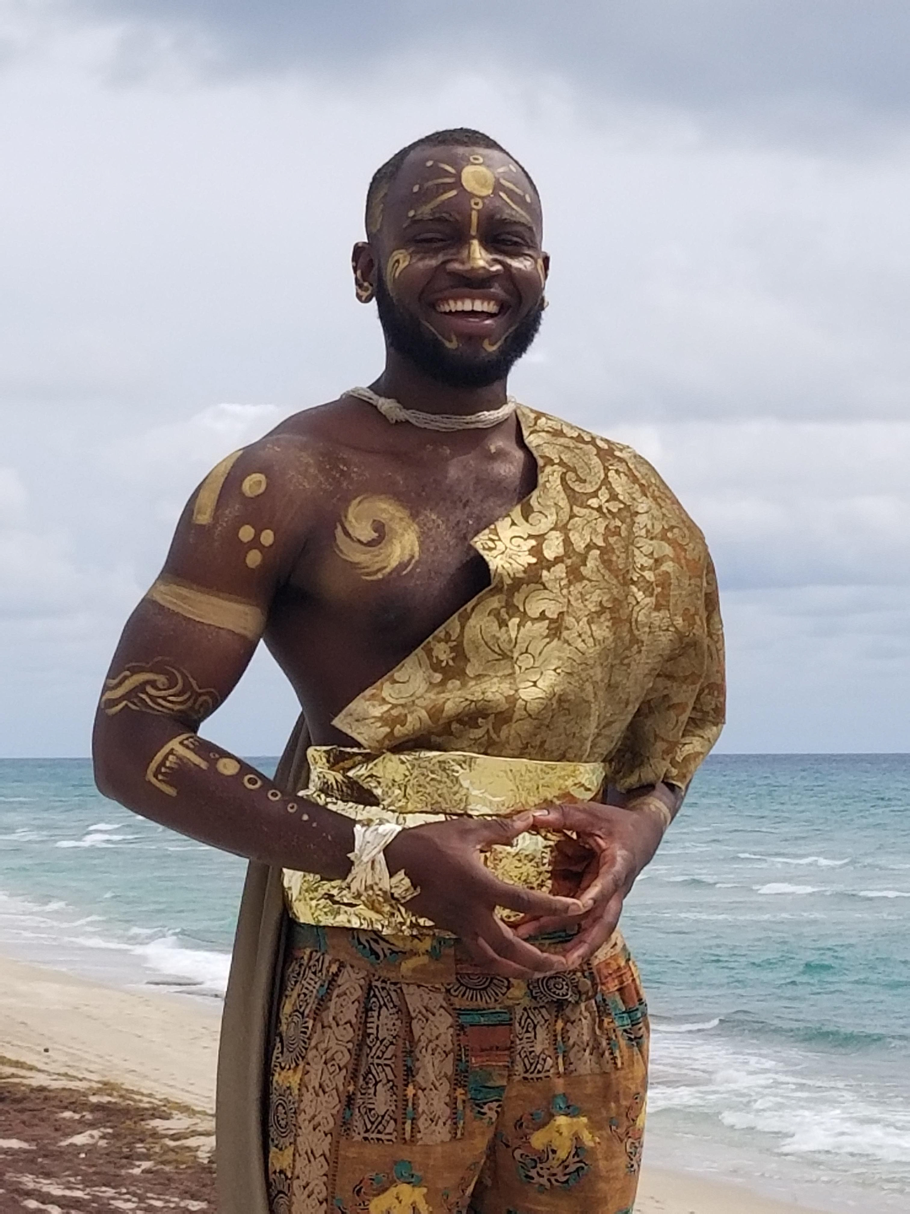 3. On the day of the photoshoot, I painted the gold designs onto my model's face and body, and dusted him with bronzer and a gold glitter. I added a beaded necklace around his neck and to his wrist for the final look.