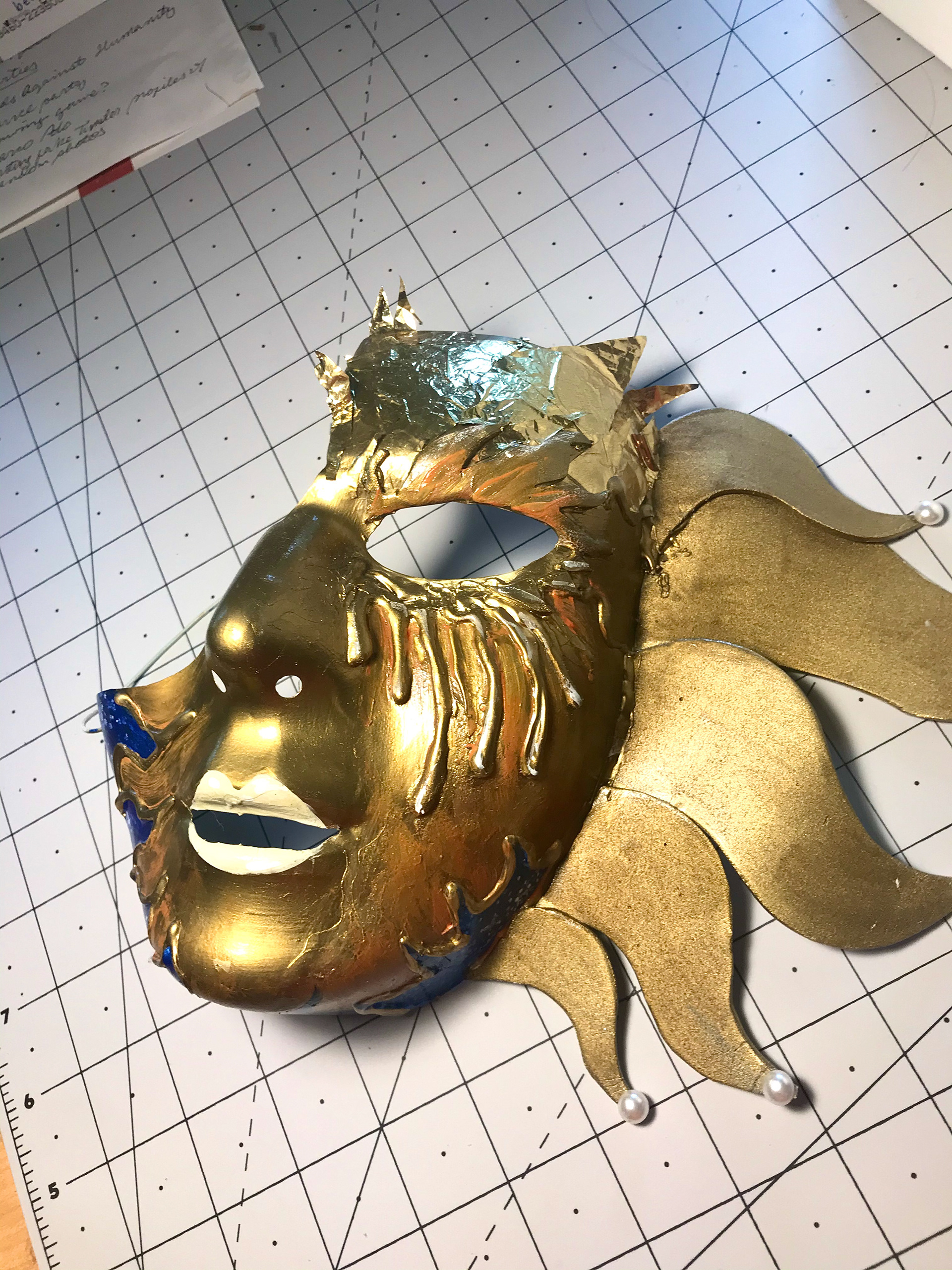6. With the same foil, I filled the forehead above the eyebrow on the sun mask. To seal both masks, I covered them with a clear coat of modge podge.