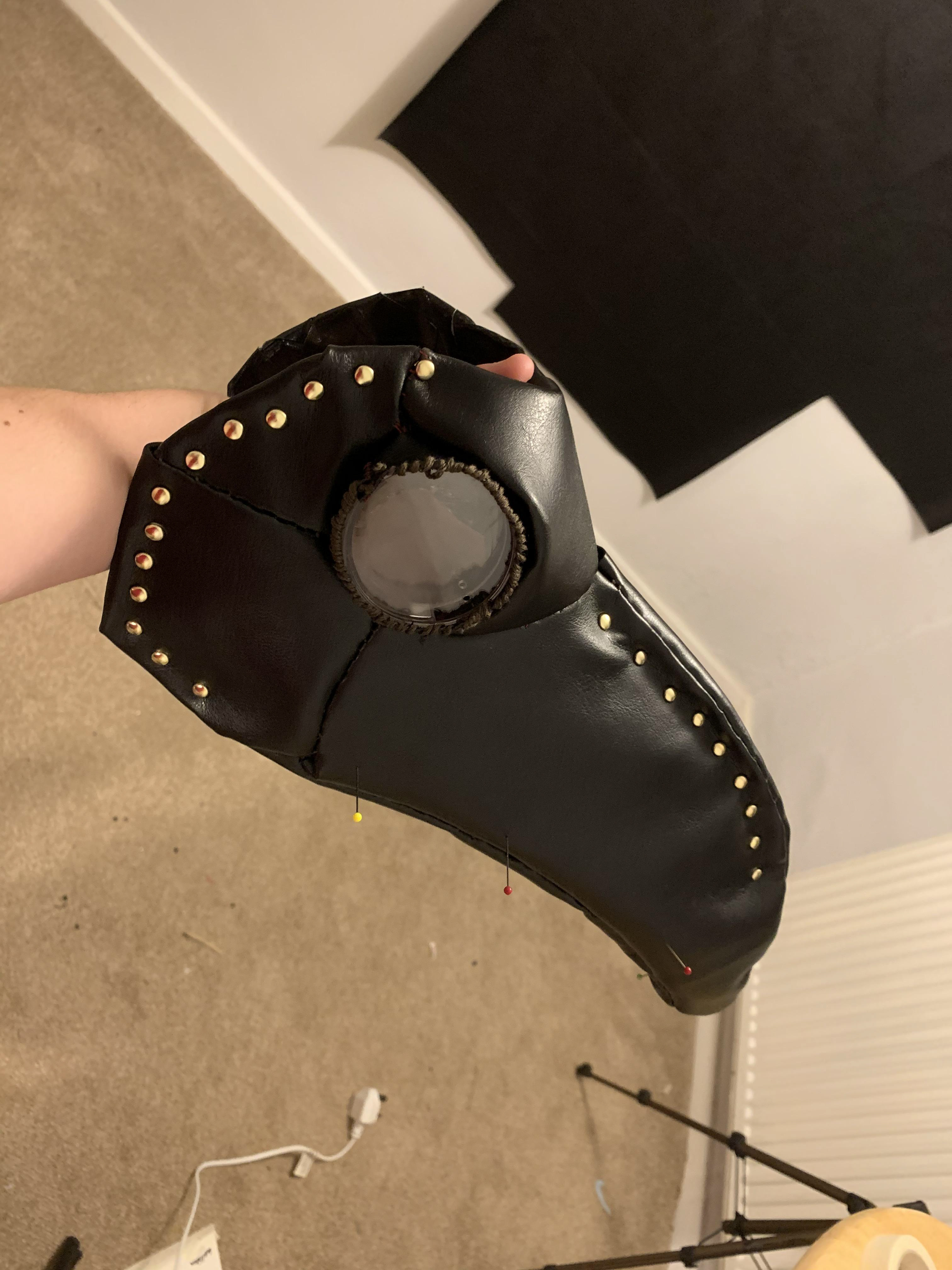 Once the pattern was sewed on, I added leather studs to fix the corners of leather to the cardboard form and ensure there was no movement from the gap between the form and the leather.