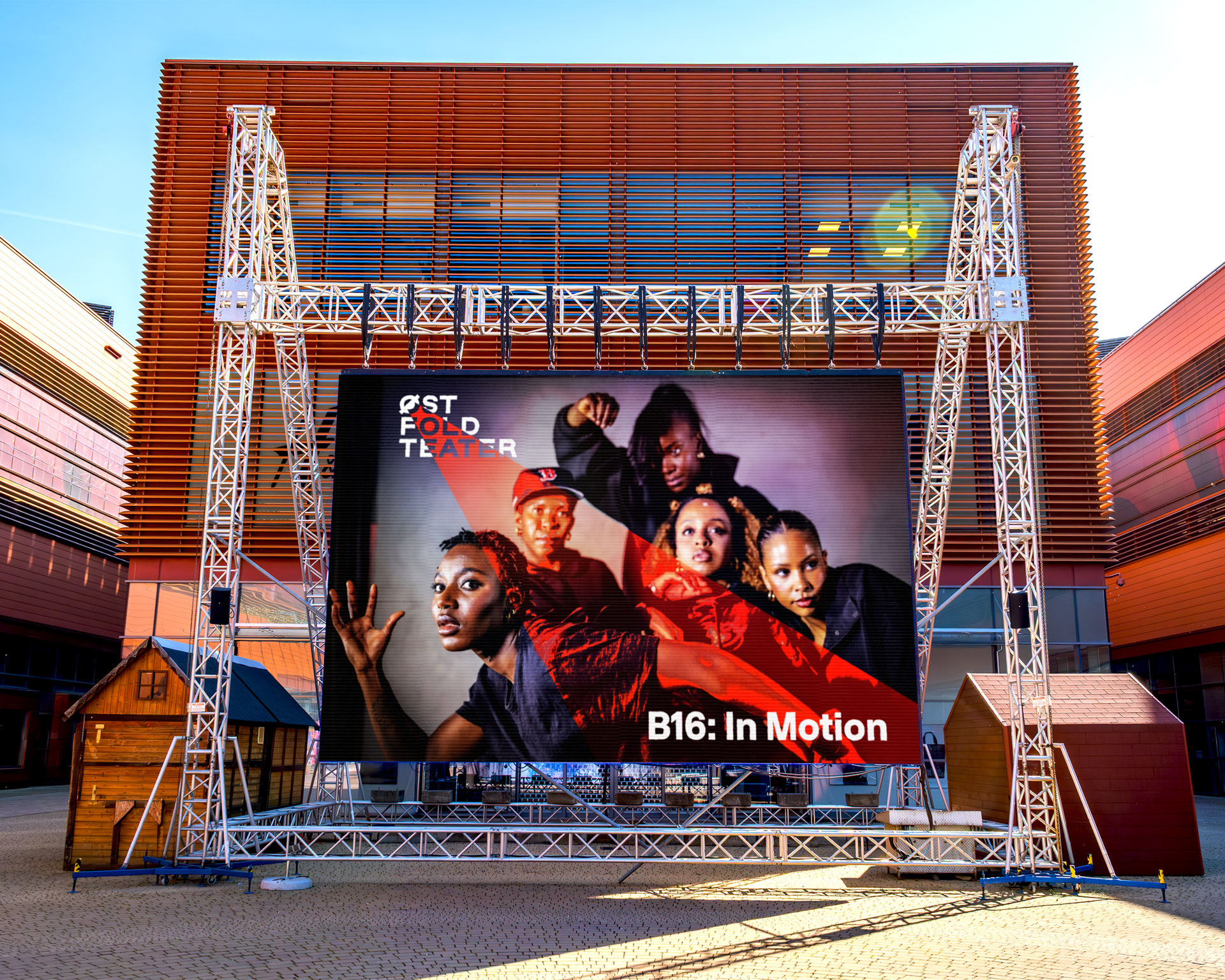 B16: In Motion på LED-storskjerm foran teaterfasade — ny visuell identitet for Østfold Teater