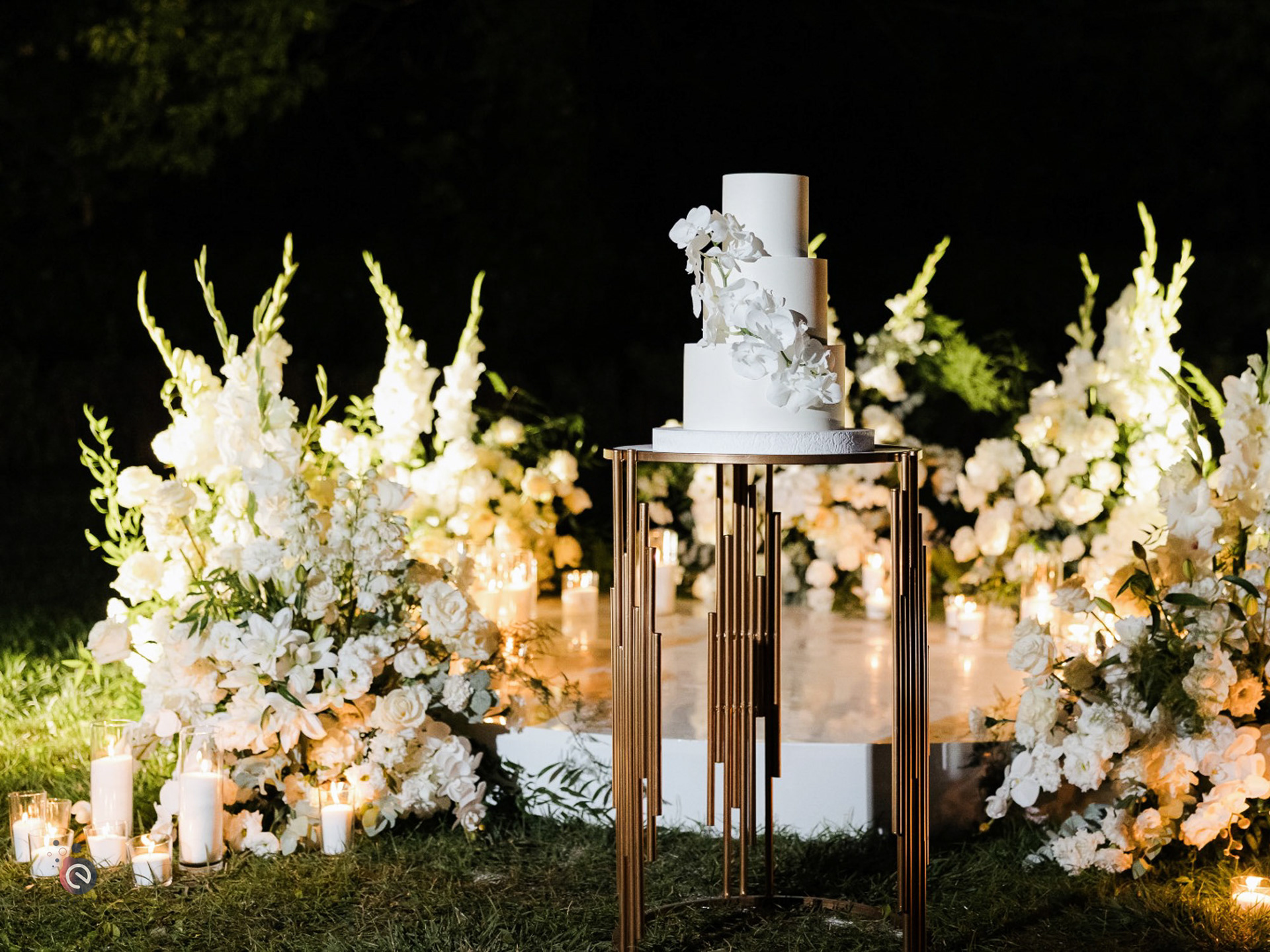 Mise en scène élégante du gâteau de mariage entouré de fleurs blanches et de bougies, décor de mariage en Belgique.