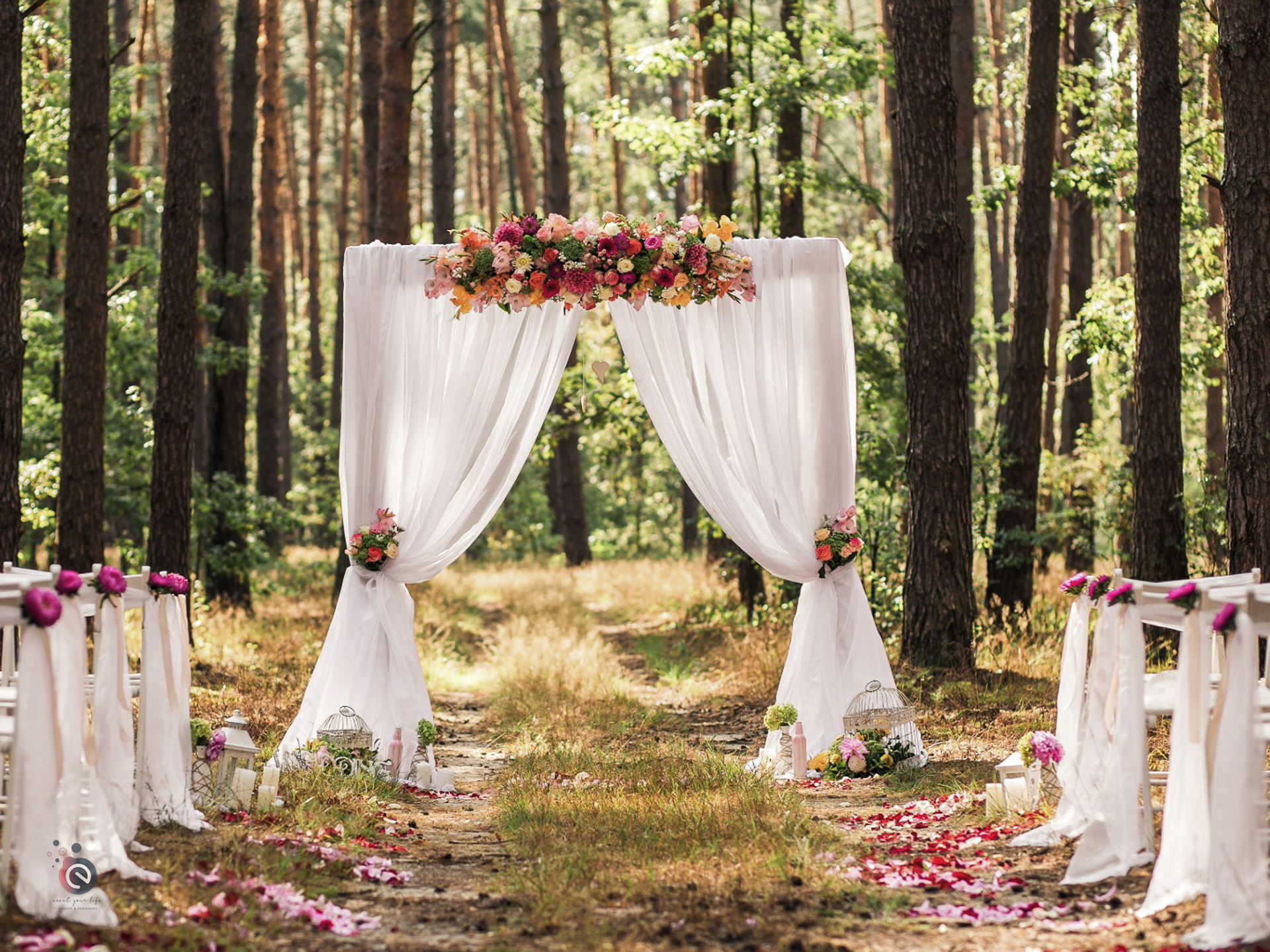 Arche de cérémonie de mariage en forêt décorée de voilages blancs et de fleurs colorées — location décoration en Belgique