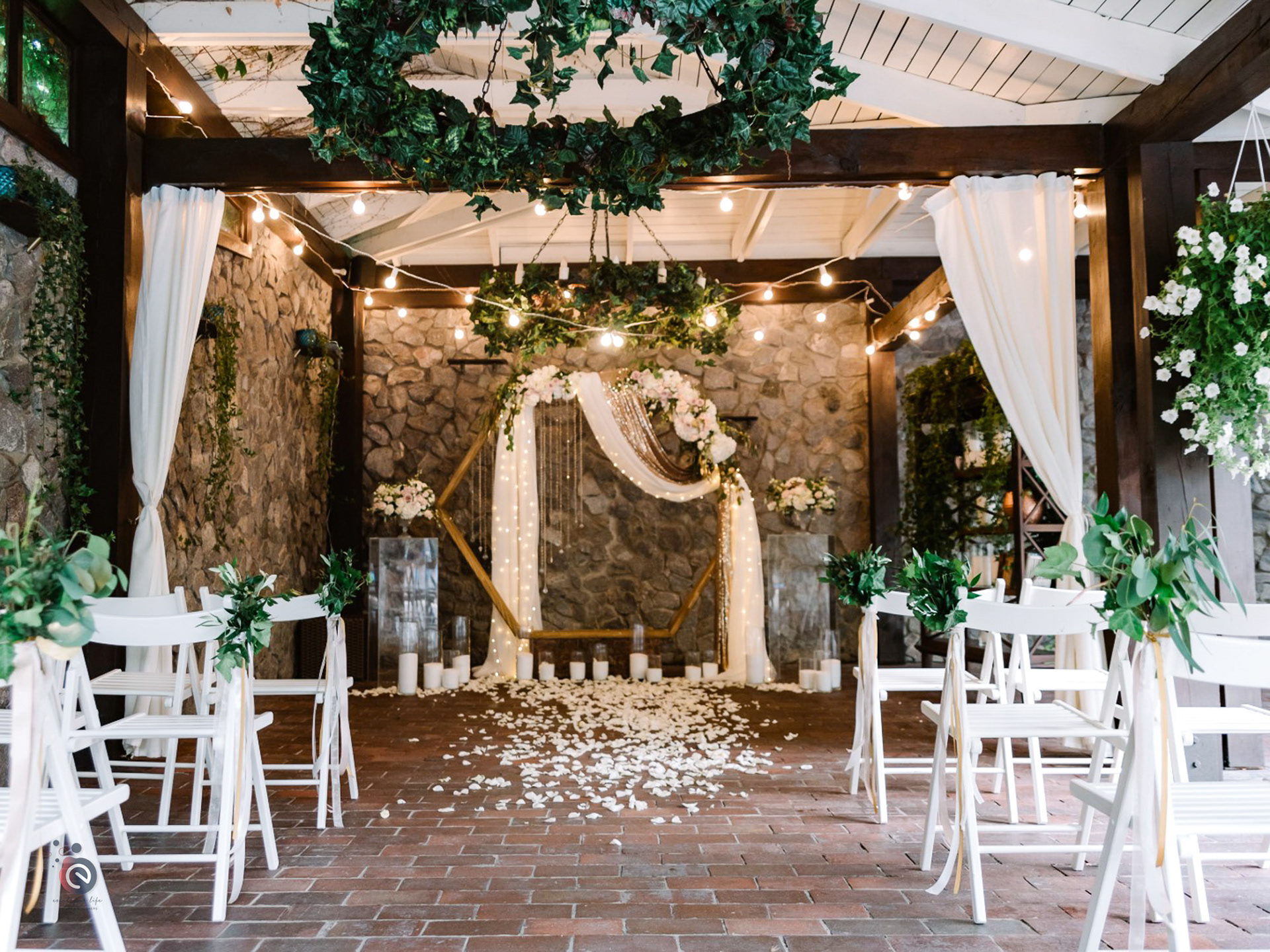 Arche hexagonale en bois décorée de voilages blancs, de fleurs et de guirlandes lumineuses — location décoration mariage en Belgique