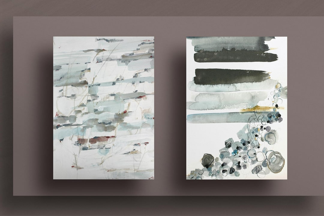 view of the artwork next to another abstract watercolor in teals, gold and grey suggesting sun coming up on the beach 