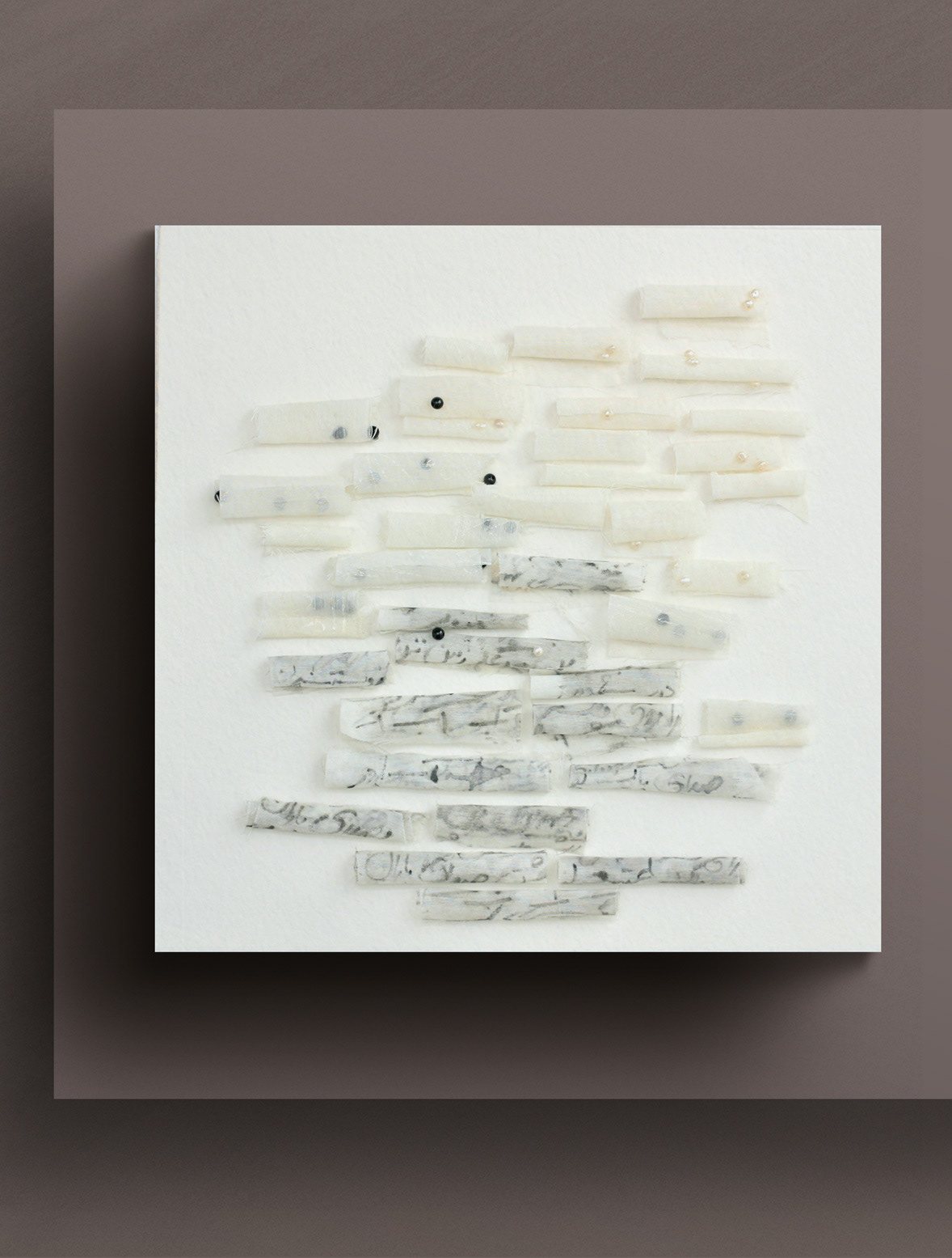 full view of artwork 37 Fabric Scrolls on mauve gallery wall The black beads and white pearls—partially veiled inside and around the scrolls