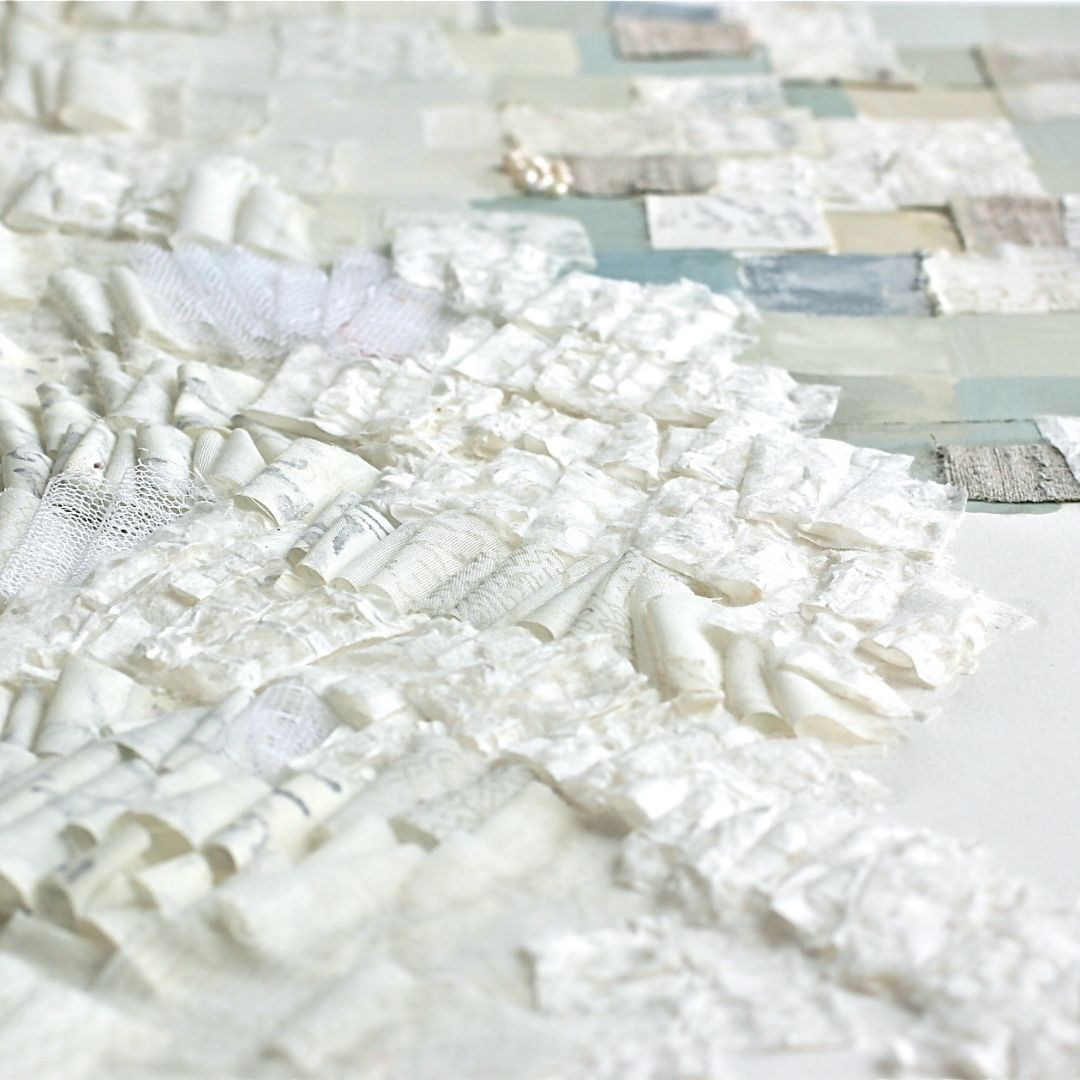 Close up view of a textile mixed media art: Vibrant patchwork of seafoam-inspired colors and textures on a flat watercolor page. Soft-edged squares in coastal hues of sandy yellows, misty blues, moss greens, and subdued turquoise. Various art materials, including gouache pigments, pearls, linen, and sheer cotton fabric and paper adorned with handwritten Persian poetry.