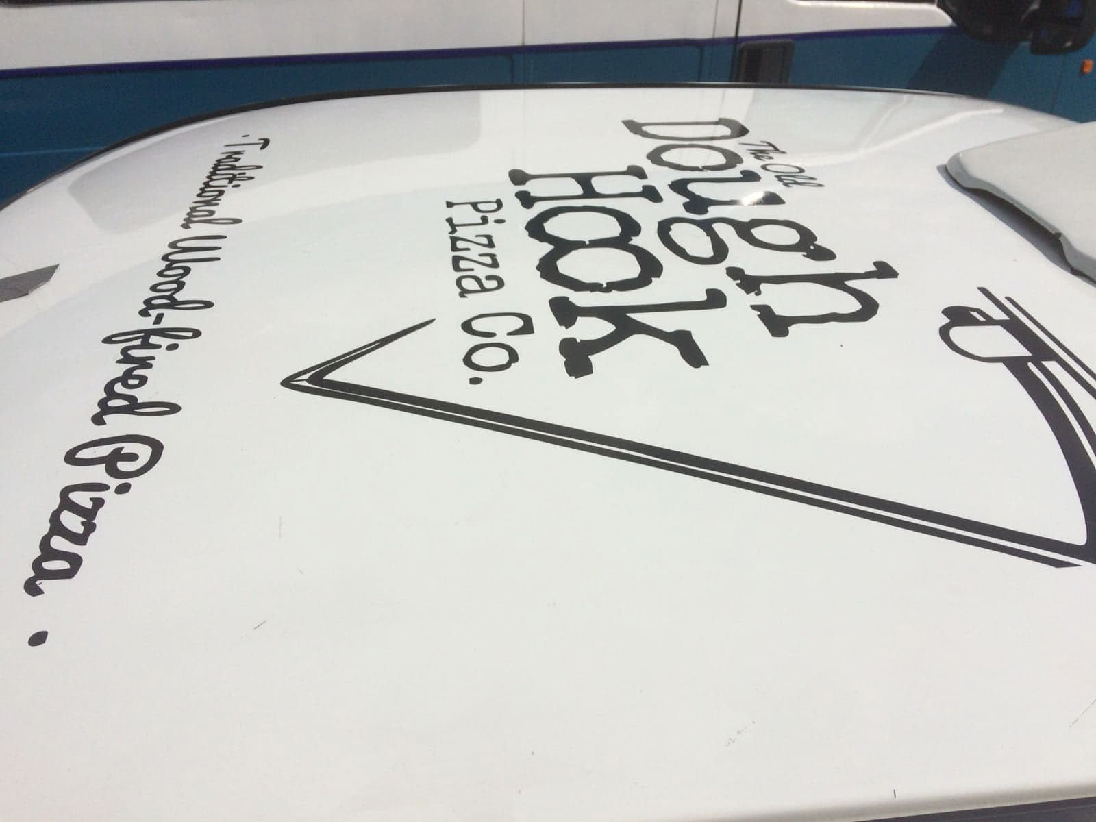 The logo design for the Old Dough Hook Pizza company used as a sponsor on a car for a racing event.
