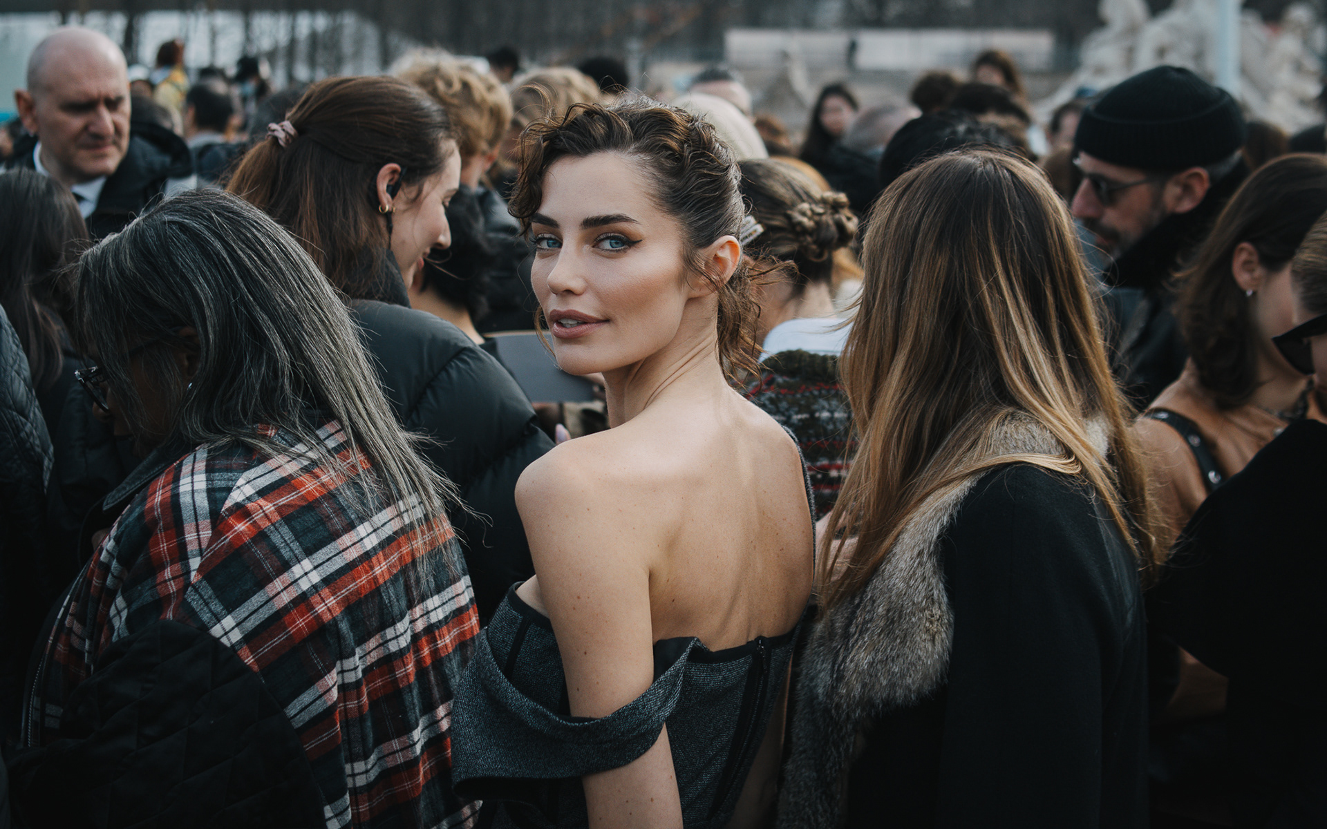 Streetstyle portrait of Rebecca Donaldson wearing Dior gray wood dress during Paris Fashion event and looking back at the camera 