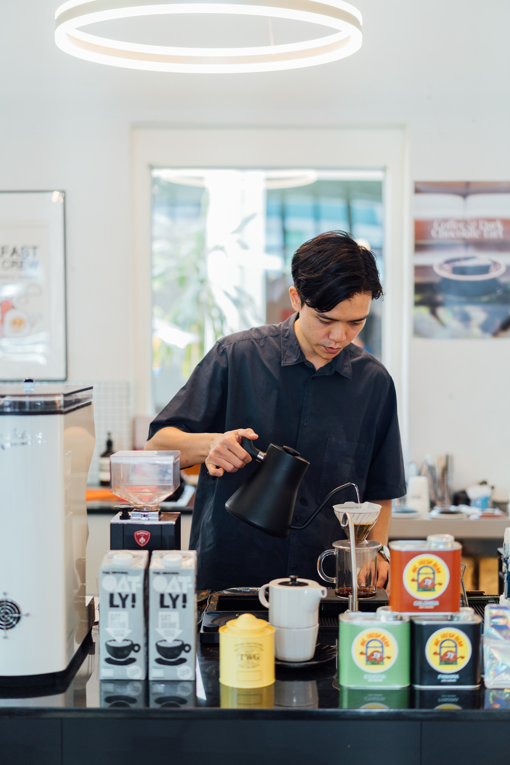 A barista is dripping coffee in the shop.
