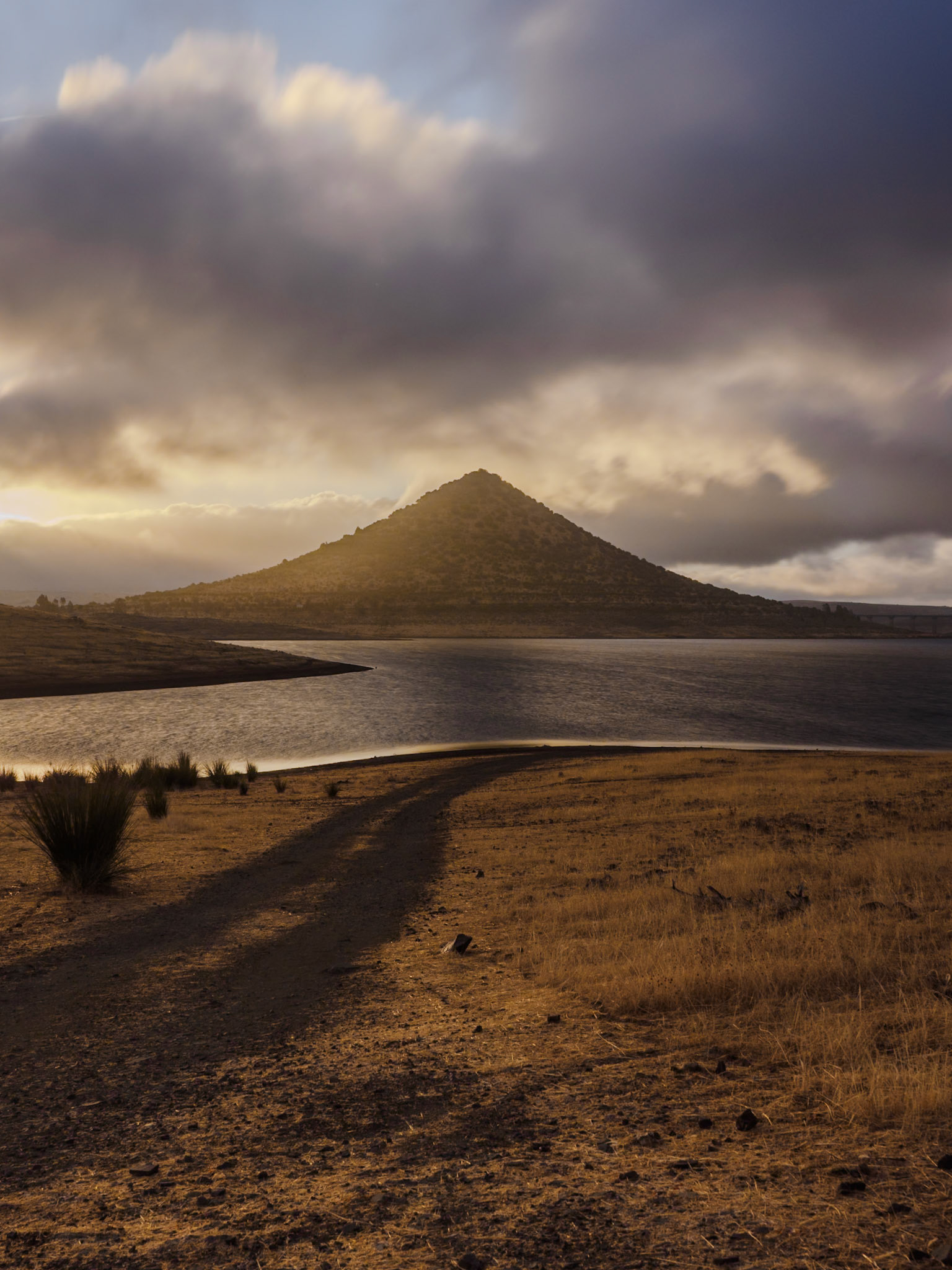 The ethereal light of dawn embraces the mystical silhouette of Cerro Masatrigo, Spain’s “Magic Mountain.”