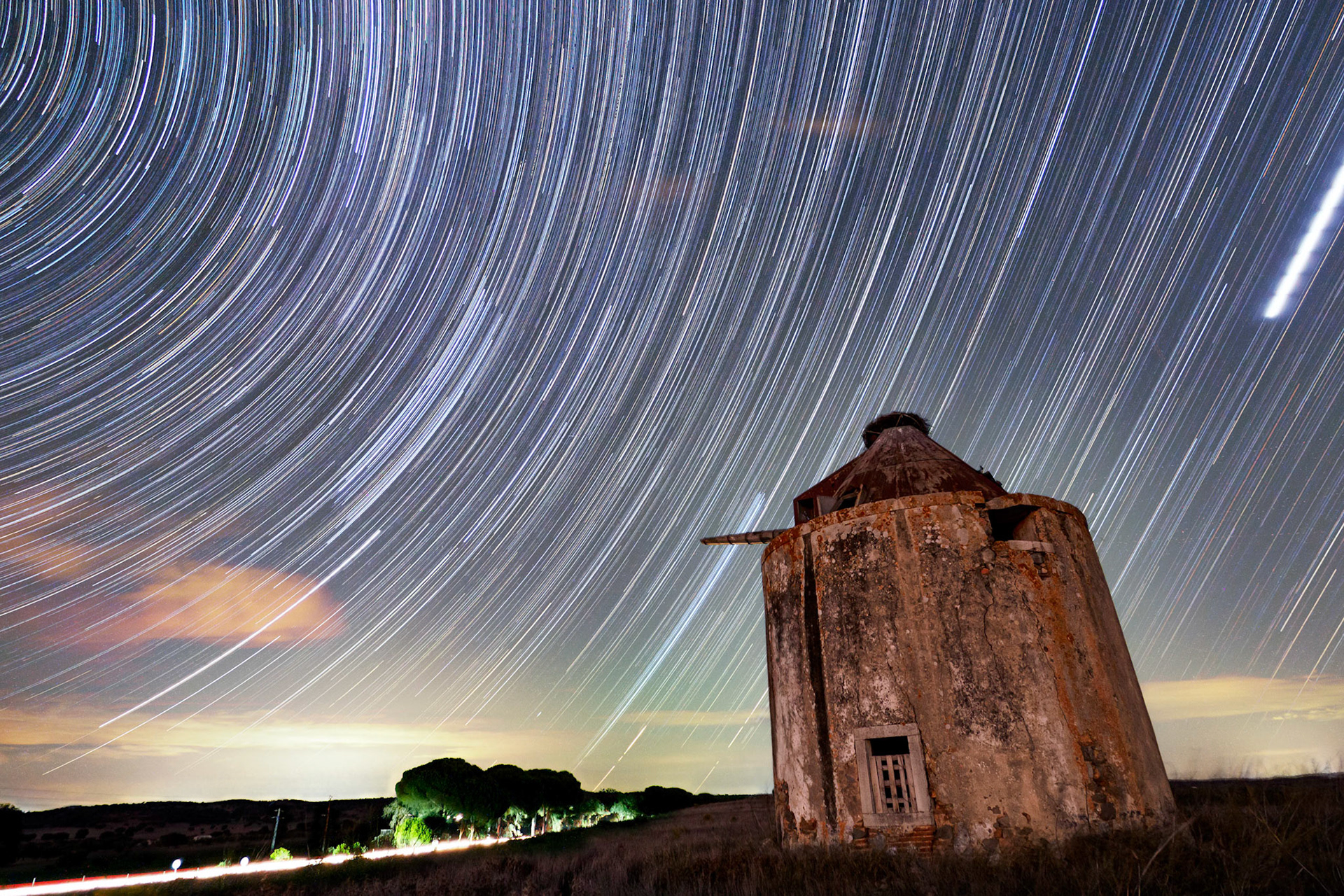 An old, windmill ruin with star trails captured with a 109-minute total exposure time