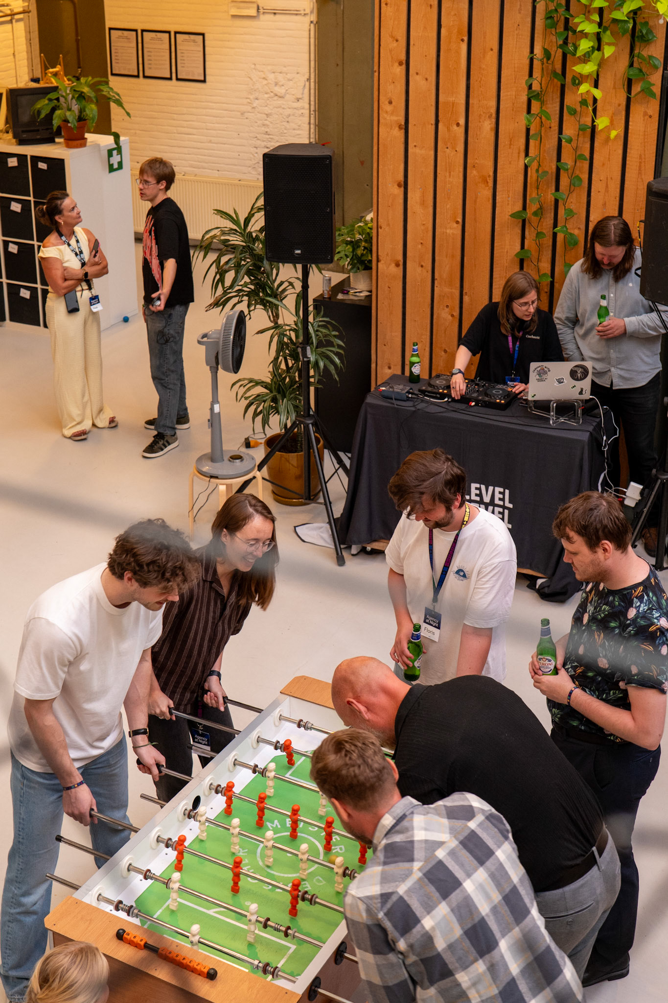 Spontane en authentieke bedrijfsfotografie van collega's met keycords tijdens een fanatiek potje tafelvoetbal op het kantoorfeest Agency at Night in Rotterdam.