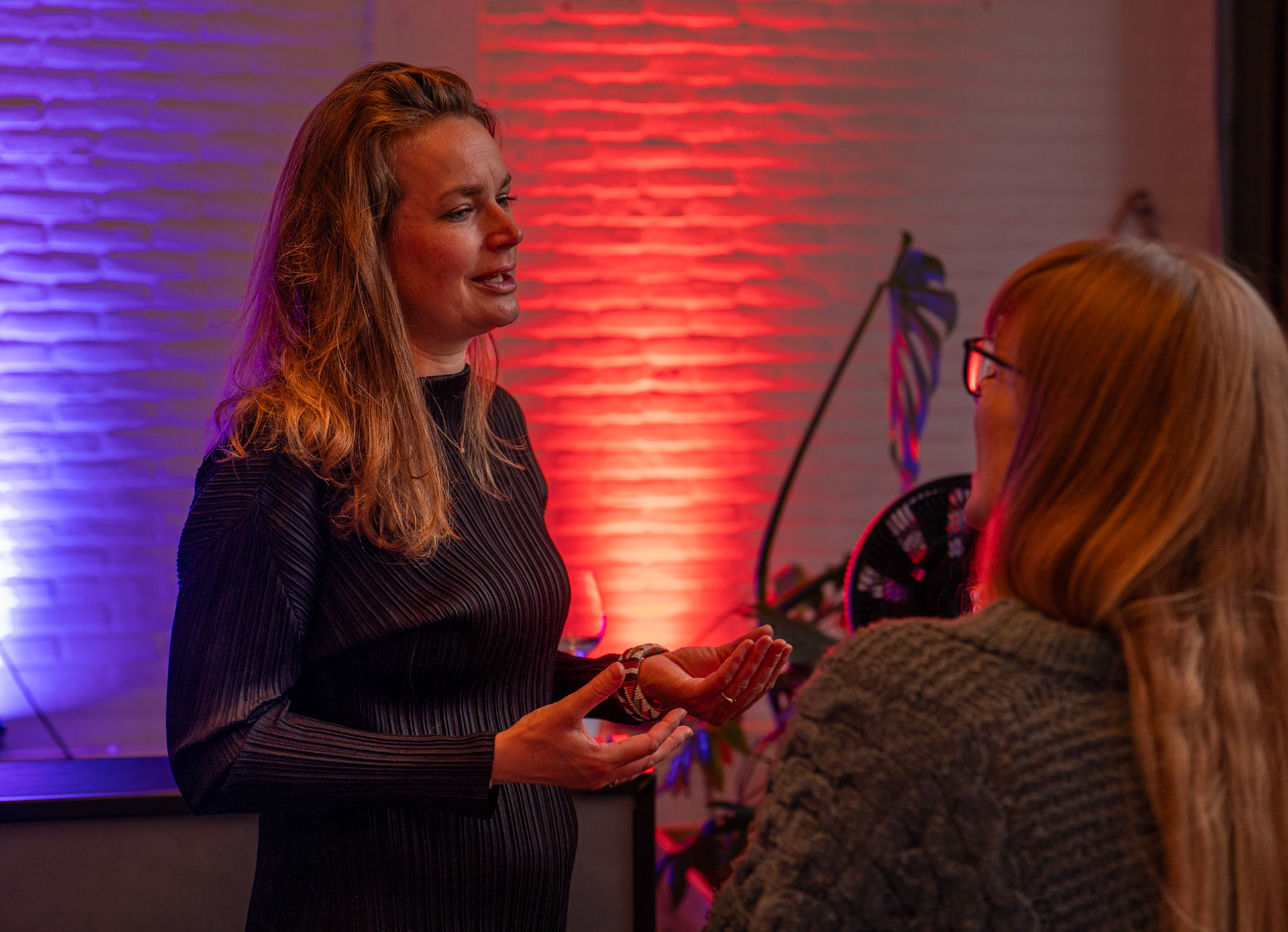 Authentieke evenementenforografie van collega's in gesprek tijdens een zakelijke borrel in Rotterdam, vastgelegd in een cinematic en ongedwongen stijl.