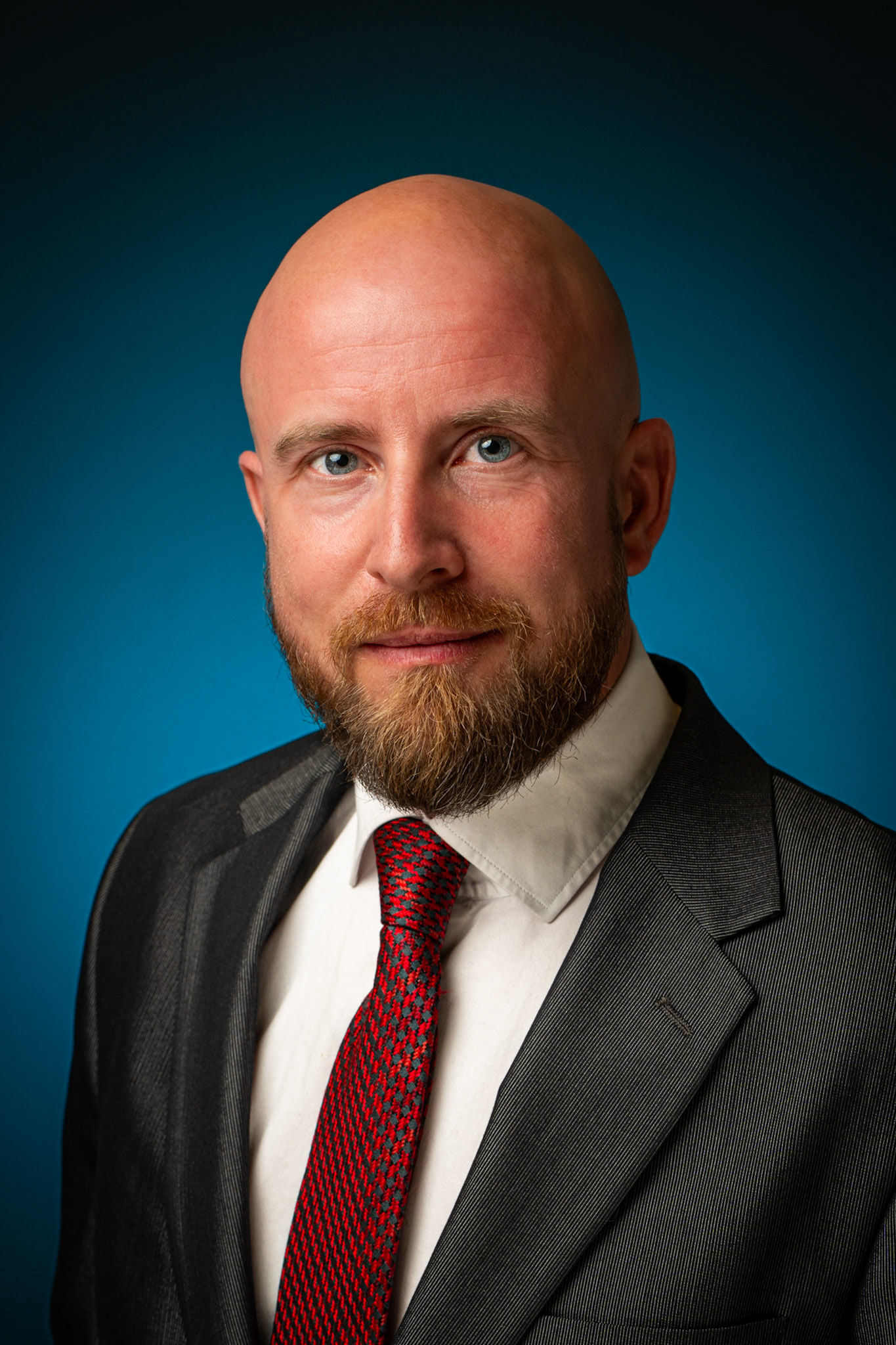 Corporate headshot van een mannelijke advocaat in pak, krachtige en betrouwbare uitstraling voor juridische dienstverlening.