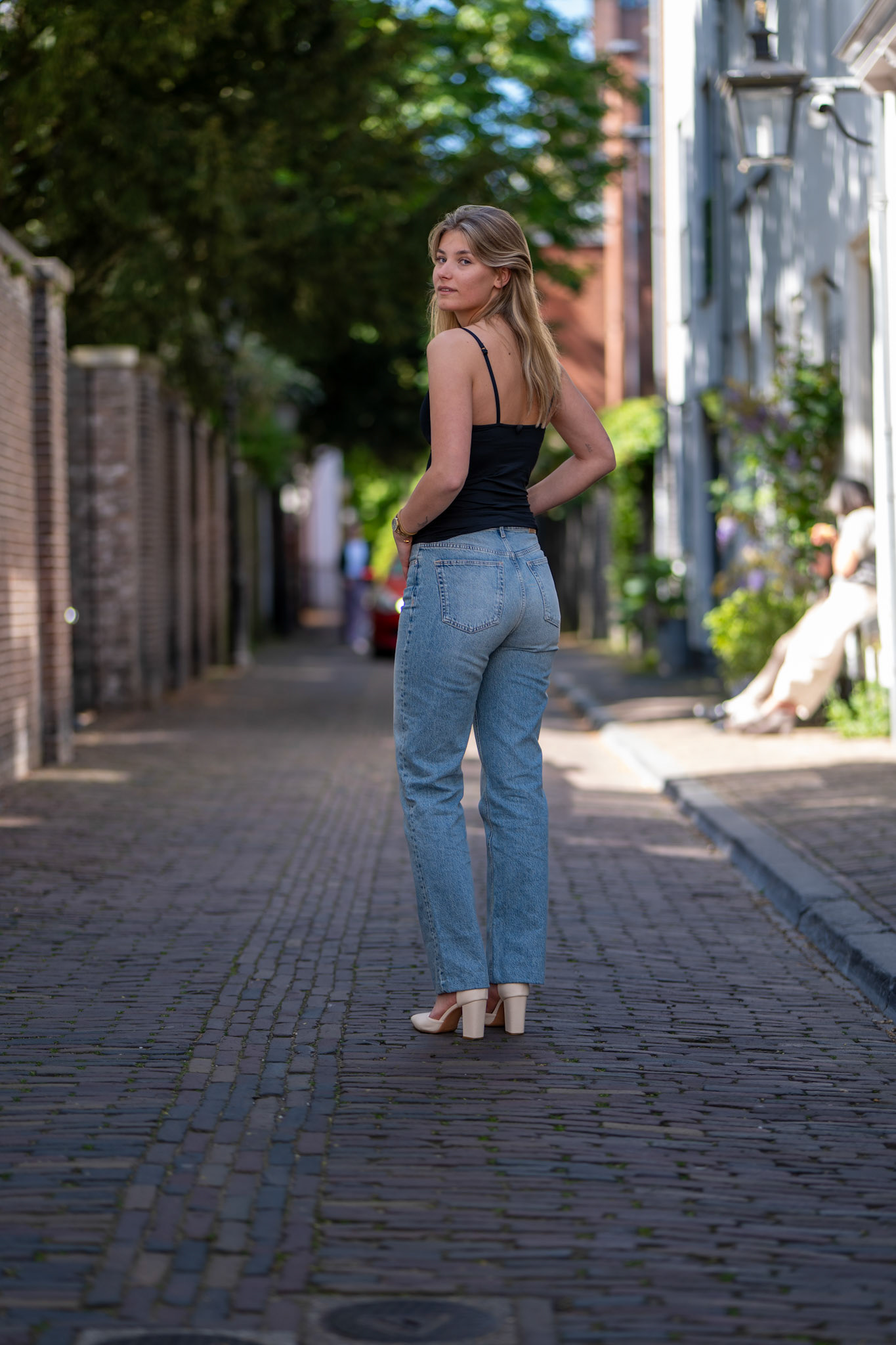 Een editorial portret van Evy, een jonge vrouw, poserend tijdens een fotoshoot in de binnenstad van Utrecht. De foto combineert mode met de karakteristieke, stedelijke achtergrond van de stad.