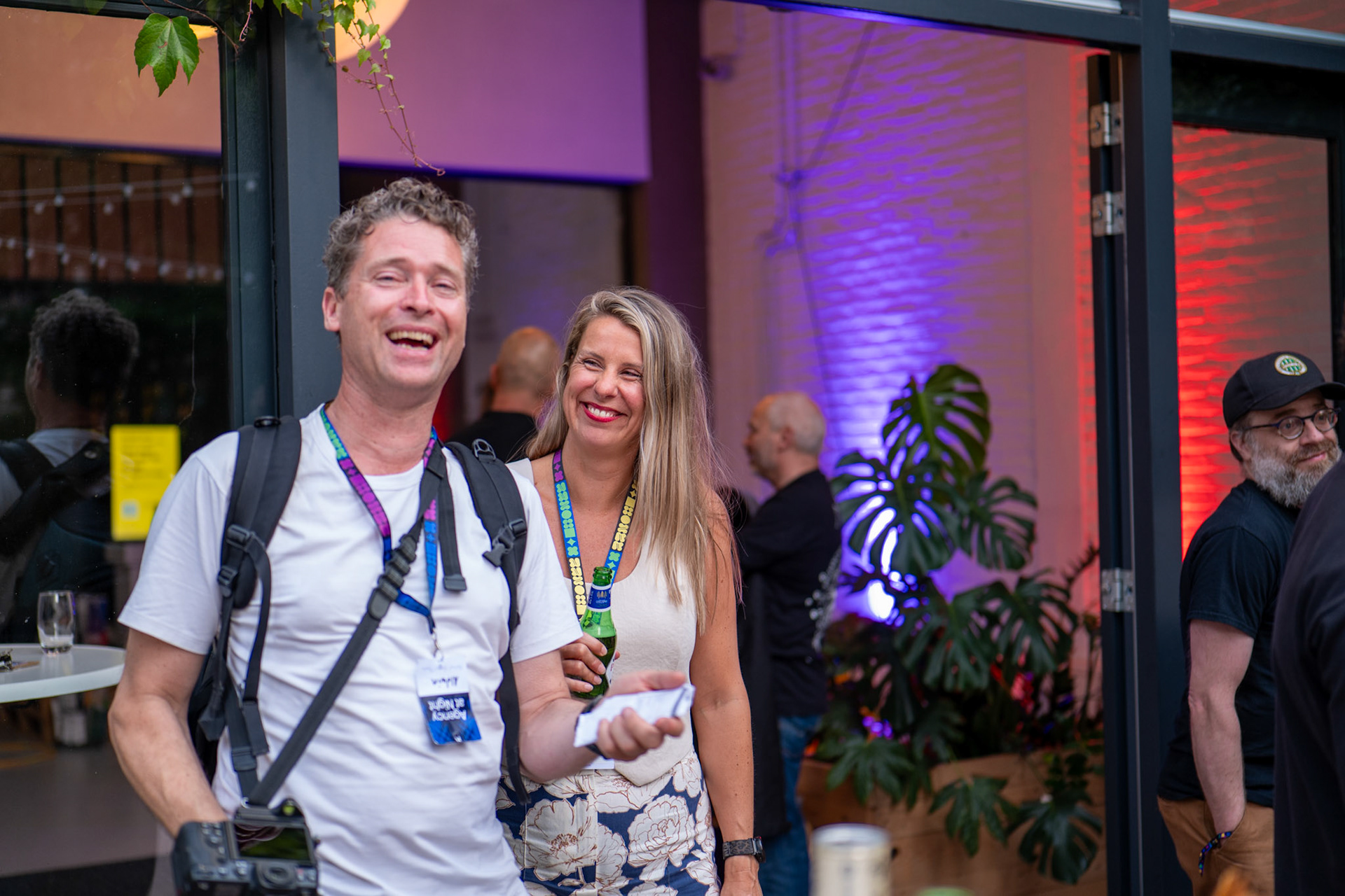 Professionele en spontane zakelijke portretfotografie van een lachende medewerker met een keycord tijdens het Agency at Night event in Rotterdam door BIECKI PHOTOGRAPHY.