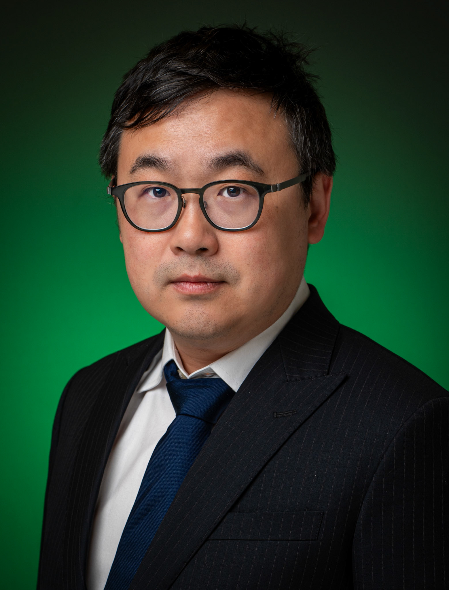 Representatieve headshot van een advocaat met een moderne studio-belichting en groen kleuraccent, gefotografeerd op locatie in Utrecht.