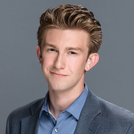 A confident young man with light brown hair looks through the screen, fully aware that anyone reading this alt text is brilliant and just his kind of collaborator.