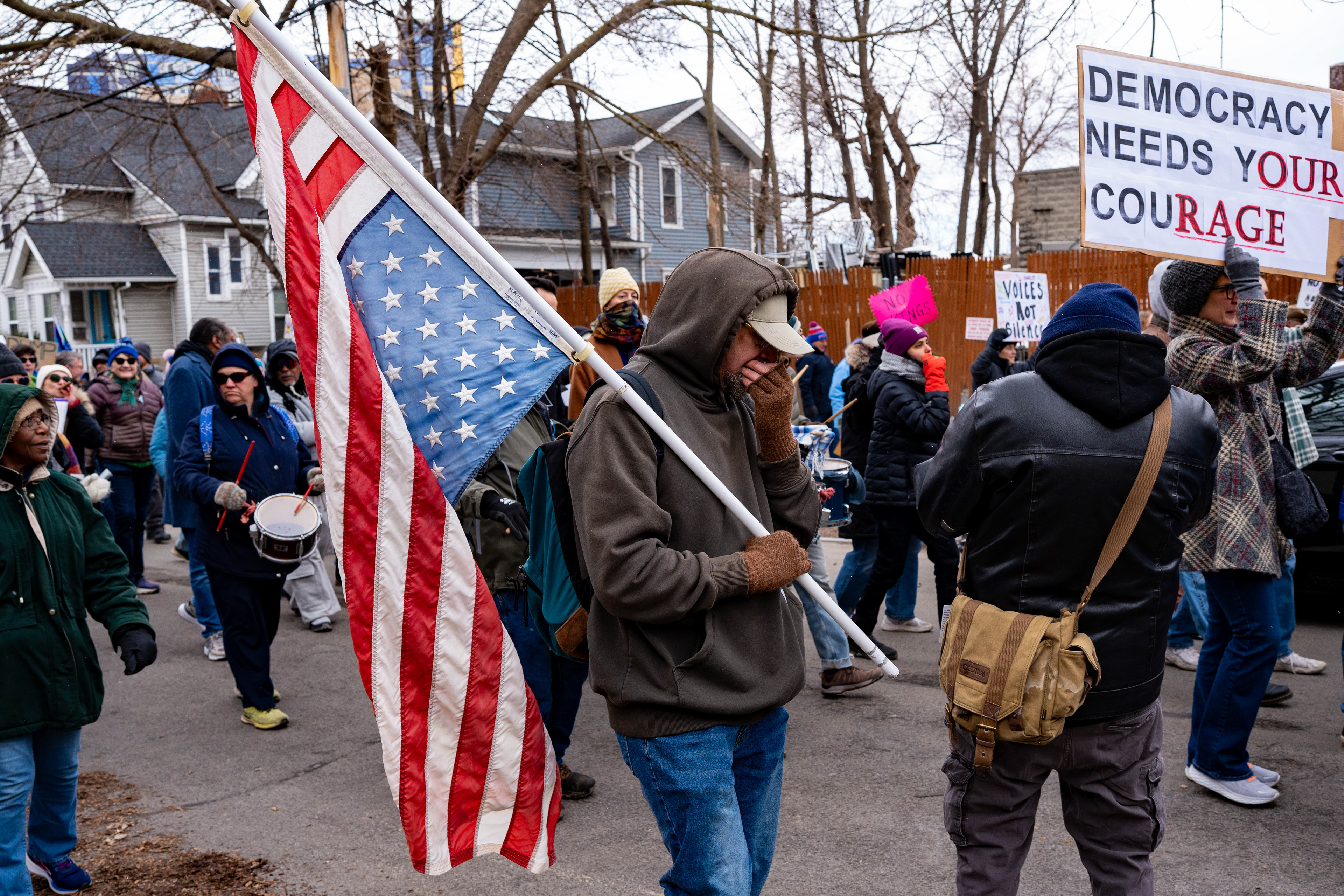 A demonstrator carries an upside-down American flag during a No Kings march from Genesee Gateway Park in Rochester, N.Y., Saturday, March 28, 2026.