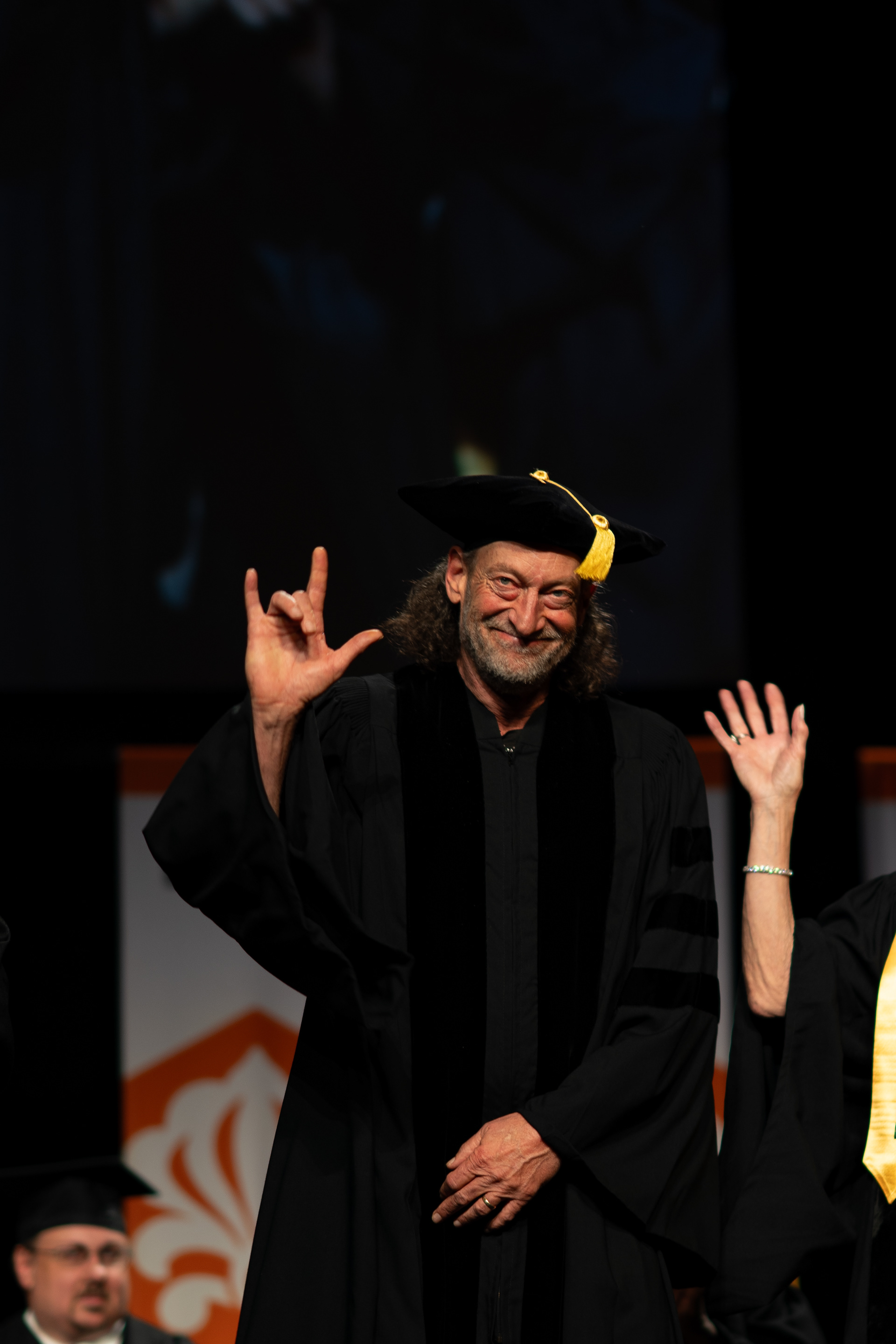 Academy Award-winning actor Troy Kotsur signs “I love you” in American Sign Language before receiving an honorary doctorate during the 2026 Academic Convocation in the Gordon Field House at the Rochester Institute of Technology in Henrietta, N.Y., Friday, May 8, 2026.