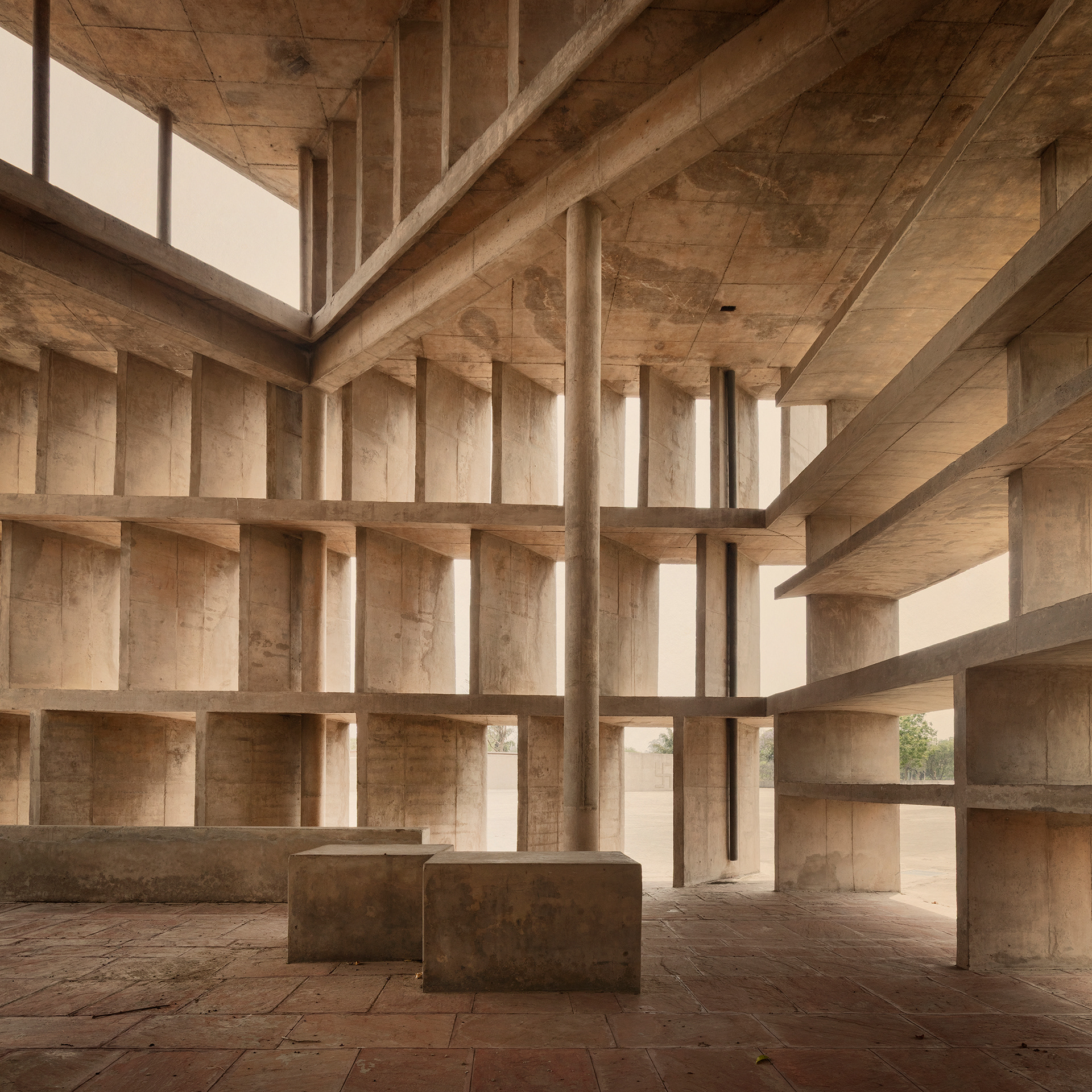 The Tower of Shadows (1955–60) is a small experimental structure designed by Le Corbusier in the Capitol Complex. Built in raw concrete, the tower was conceived as an architectural study of the relationship between light and shadow in India’s intense climate. Each of its façades features different brise-soleil systems, designed according to the orientation of the sun, allowing direct sunlight to be blocked while permitting air and diffused light to pass through. More than a functional building, the Tower of Shadows serves as a climatic and pedagogical manifesto, demonstrating how architecture can control sunlight and create comfort through form and orientation.