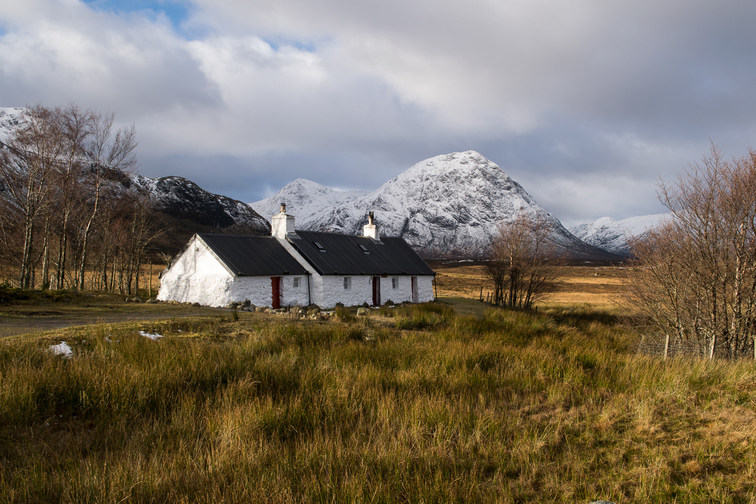 photo of Blackrock cottage in November with the snow covered Buachaille Etive Mor in the background