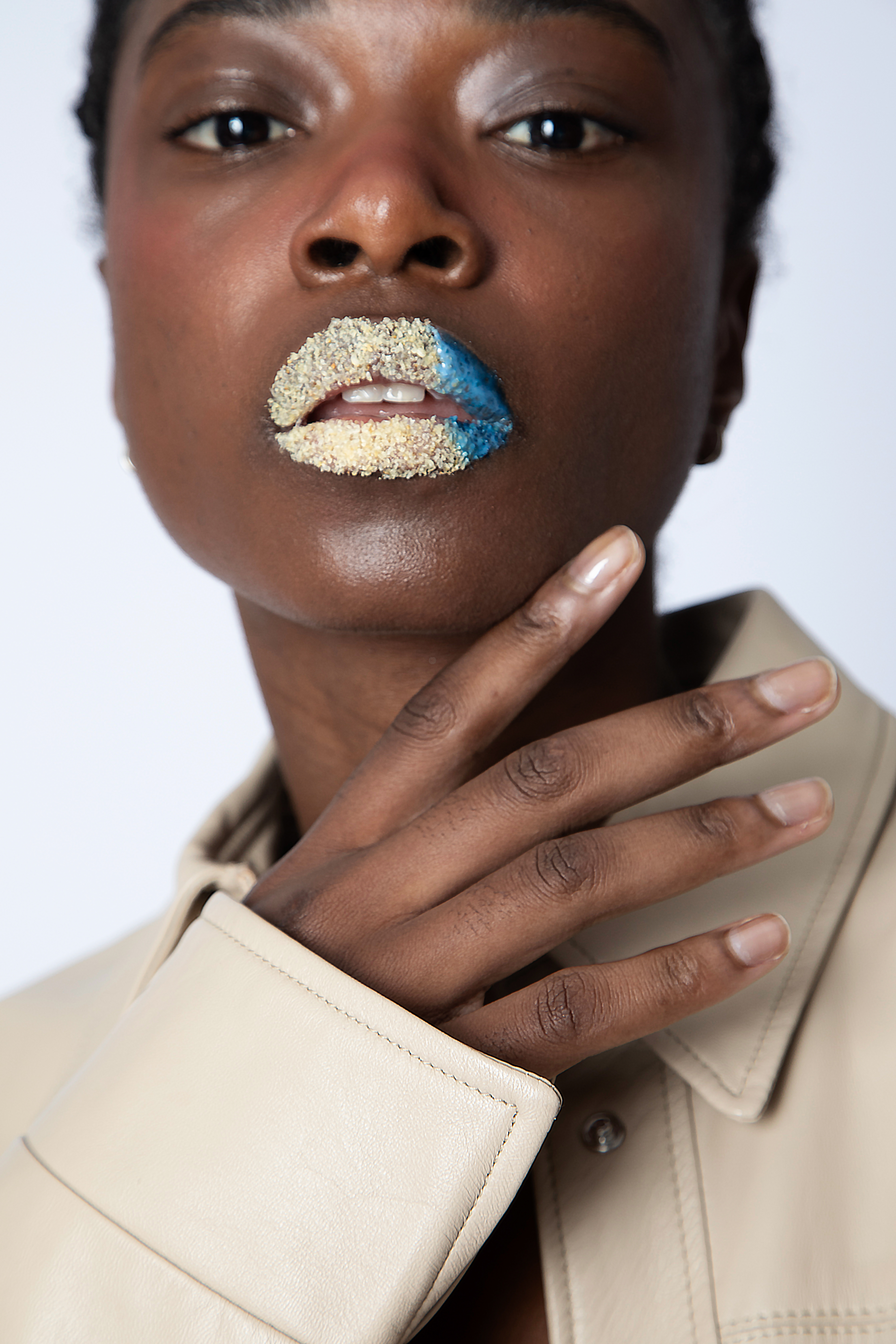 DESERT  Tipologia: Makeup fashion, focus labbra;  Caratteristiche: Focus sulle labbra con un effetto materico caratterizzato da texture contrastanti. Una parte opaca e granulare richiama il deserto, mentre una sezione lucida rappresenta l'oceano, creando un equilibrio visivo unico; Type: Fashion makeup, lip-focused; Features: A textural focus on the lips with contrasting finishes. A matte, grainy texture evokes the desert, while a glossy section represents the ocean, creating a unique visual balance; Makeup e hair: Gino Aurora;