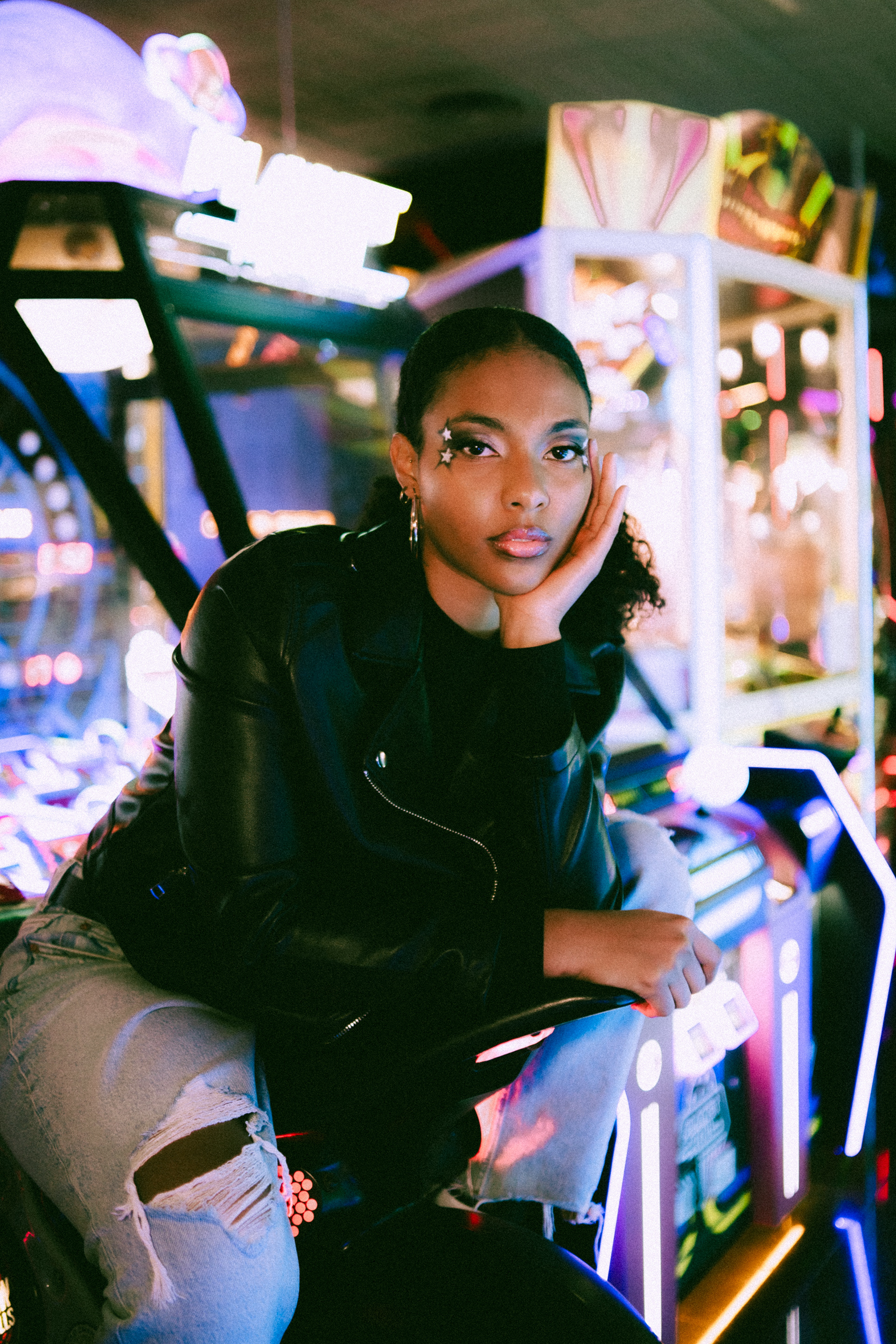 Y2K Arcade Tipologia: Makeup editoriale, artistico;  Caratteristiche:Makeup fortemente ispirato agli anni 2000, caratterizzato da stelle luminose che contrastano con la pelle della modella. Le labbra richiamano chiaramente la moda dei primi anni 2000; Type: Editorial, artistic makeup; Features: A makeup look heavily inspired by the 2000s, featuring bright stars that contrast with the model’s skin. The lips are a clear reference to early 2000s fashion;