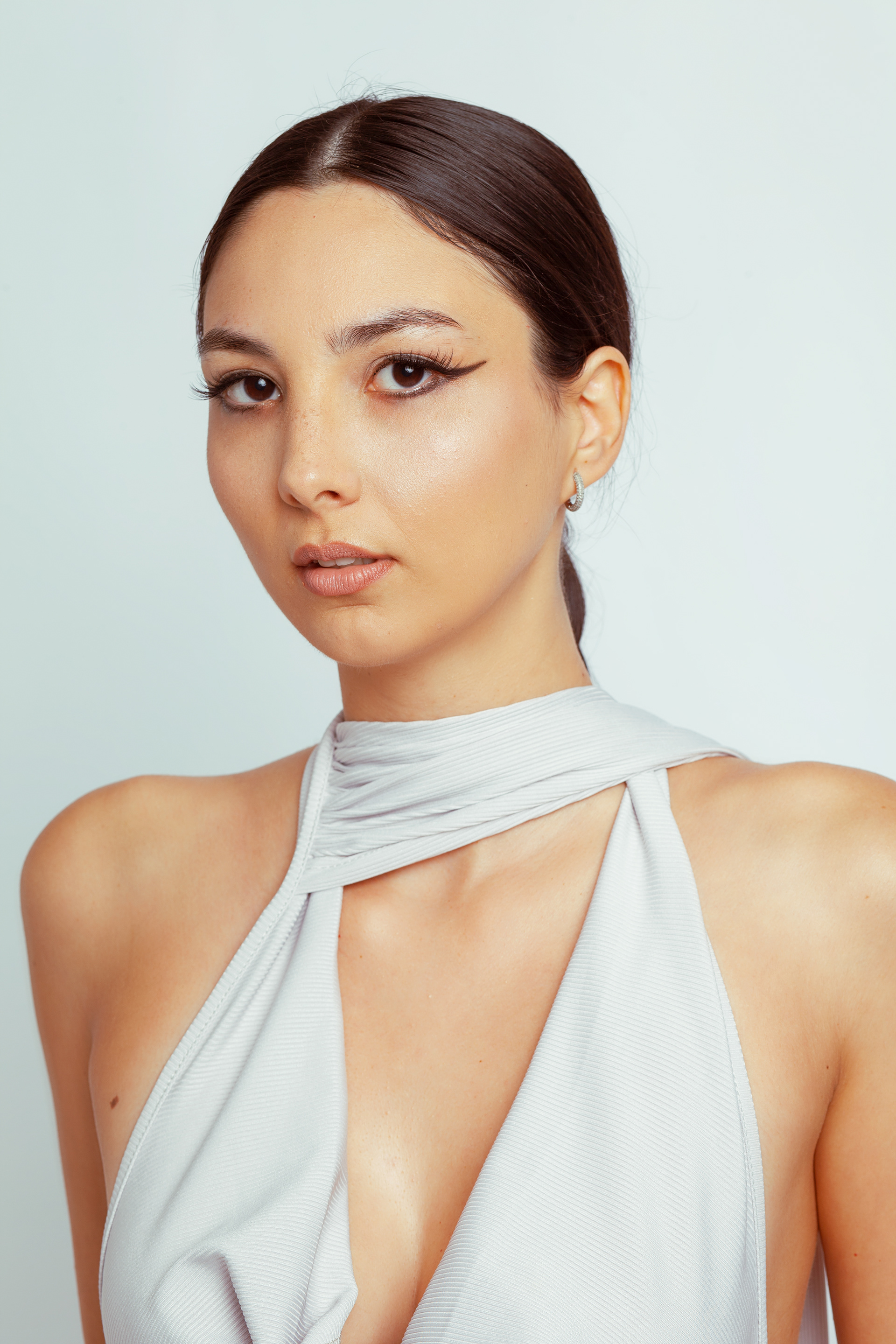 Tipologia: Makeup editoriale; Caratteristiche: Base viso leggera e luminosa, pensata per esaltare le luci del set fotografico. Il makeup è focalizzato sugli occhi con un eyeliner allungato e ben definito; Type: Editorial makeup; Features: Lightweight and radiant face base designed to enhance the lighting on the photo set. The makeup focuses on the eyes with elongated and well-defined eyeliner; Makeup e hair: Gino Aurora; 