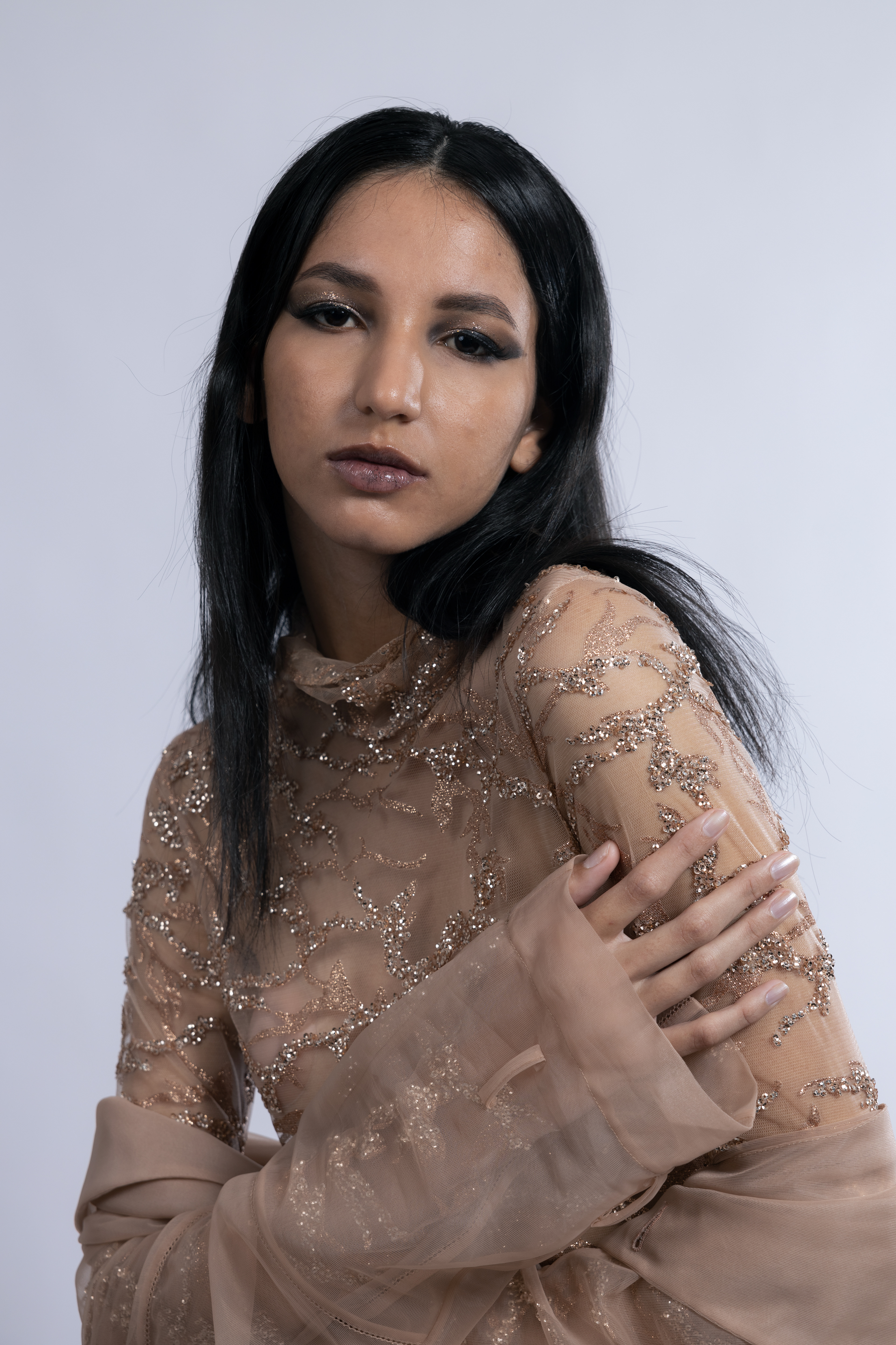 Tipologia: Makeup fashion; Caratteristiche: Smokey eyes allungato e intenso, arricchito da glitter che riprendono i dettagli del vestito per un look armonioso e glamour;  Type: Fashion makeup; Features: Elongated and intense smokey eyes, enhanced with glitter that mirrors the details of the outfit, creating a harmonious and glamorous look;  Makeup e hair: Gino Aurora;