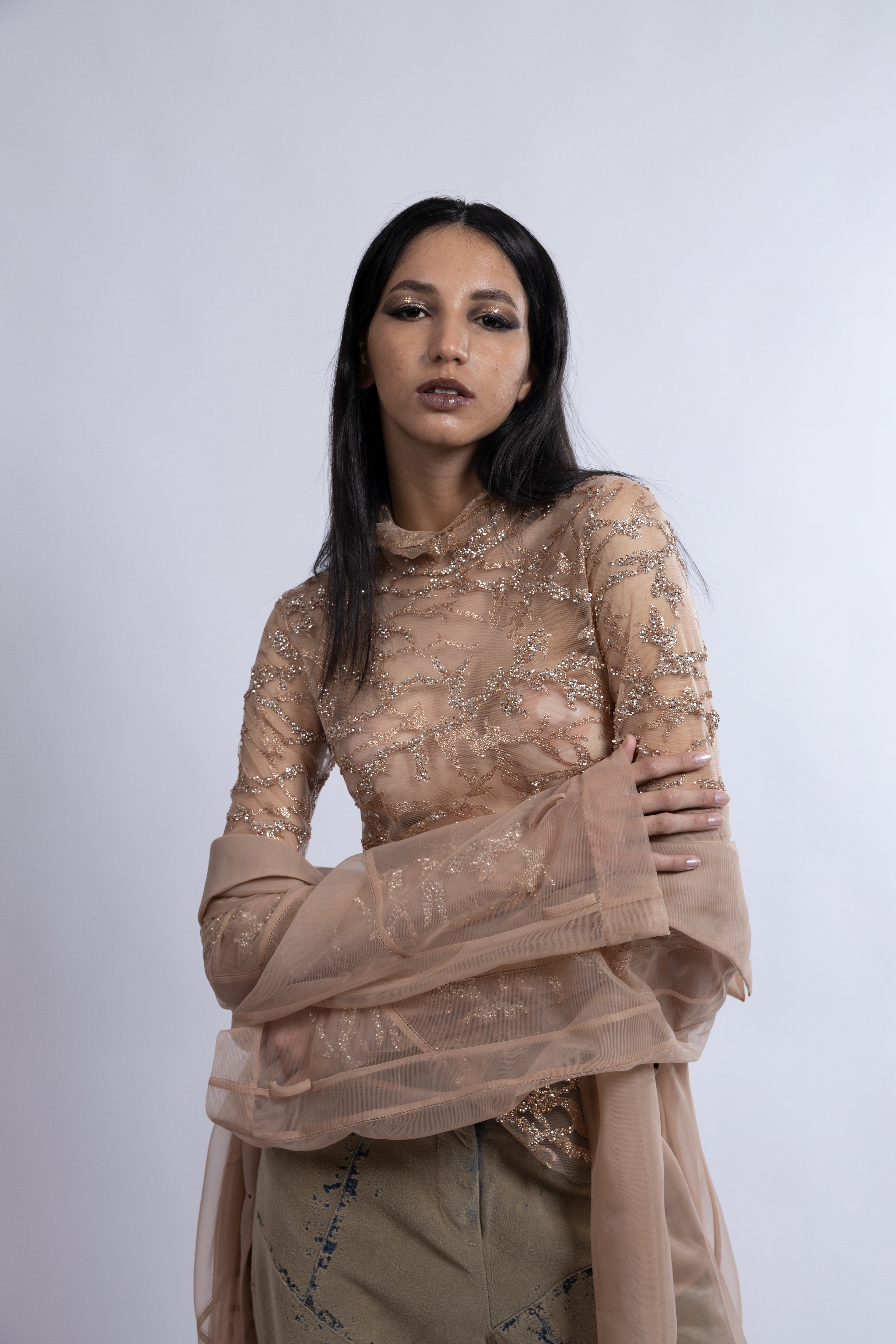 Tipologia: Makeup fashion; Caratteristiche: Smokey eyes allungato e intenso, arricchito da glitter che riprendono i dettagli del vestito per un look armonioso e glamour;  Type: Fashion makeup; Features: Elongated and intense smokey eyes, enhanced with glitter that mirrors the details of the outfit, creating a harmonious and glamorous look;  Makeup e hair: Gino Aurora;