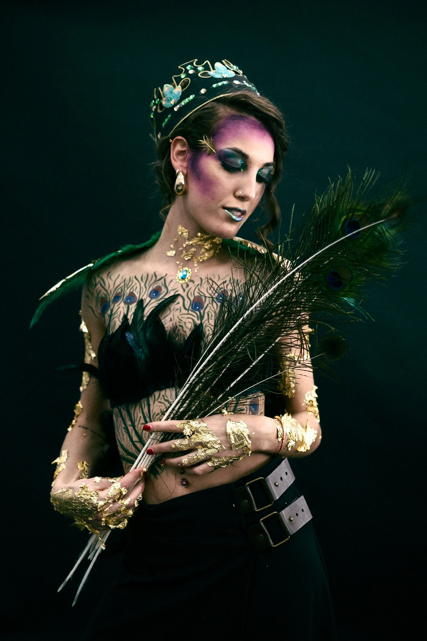 PEACOCK QUEEN Tipologia: Makeup artistico, body painting; Caratteristiche: L'ispirazione per questo progetto nasce dai peccati capitali di superbia, gola e lussuria. Sono state utilizzate diverse tecniche, come la creazione di stencil e l'applicazione di foglia oro. Anche il copricapo a forma di corona è stato realizzato su misura per il progetto; Type: Artistic makeup, body painting; Features: The inspiration for this project comes from the deadly sins of pride, gluttony, and lust. Various techniques were used, including stencil creation and gold leaf application. The crown-shaped headpiece was also custom-made for this project; Makeup e headpiece: Gino Aurora;
