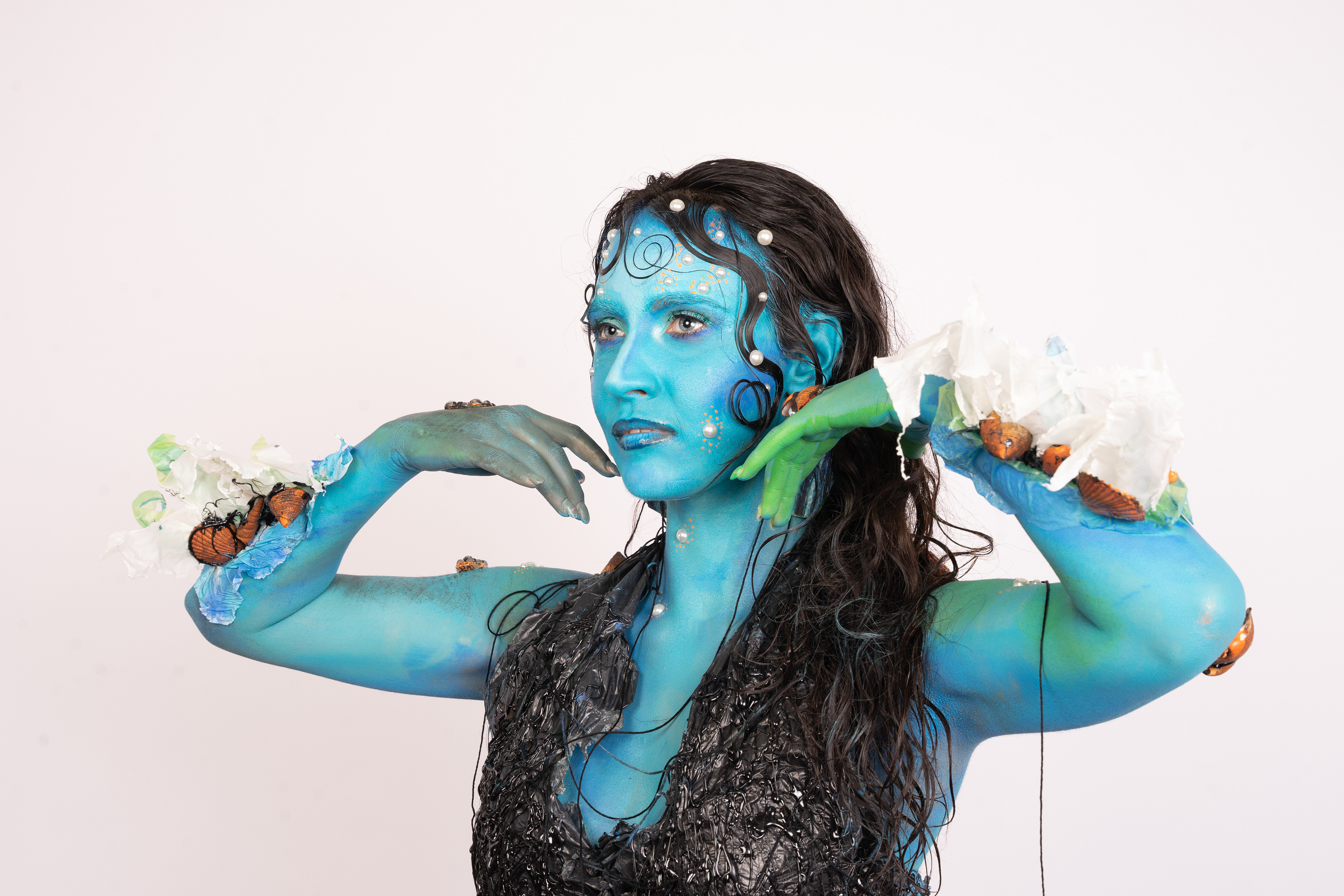 SURVIVED MERMAID Tipologia: Makeup artistico, body painting; Caratteristiche: Il tema di questo progetto è il riciclo. Abbiamo creato una sirena che, per sopravvivere in un mare inquinato, si è fusa con i materiali circostanti, come la plastica. Sono state utilizzate diverse tecniche di bodypainting e makeup artistico. Tutti gli elementi accessori, come pinne, branchie e top, sono stati realizzati utilizzando materiali di scarto; Type: Artistic makeup, body painting; Features: The theme of this project is recycling. We designed a mermaid who, to survive in a polluted sea, has merged with the materials around her, such as plastic. Various body painting and artistic makeup techniques were employed. All accessory elements, including fins, gills, and the top, were made using recycled materials; Makeup hair accessories: Gino Aurora;