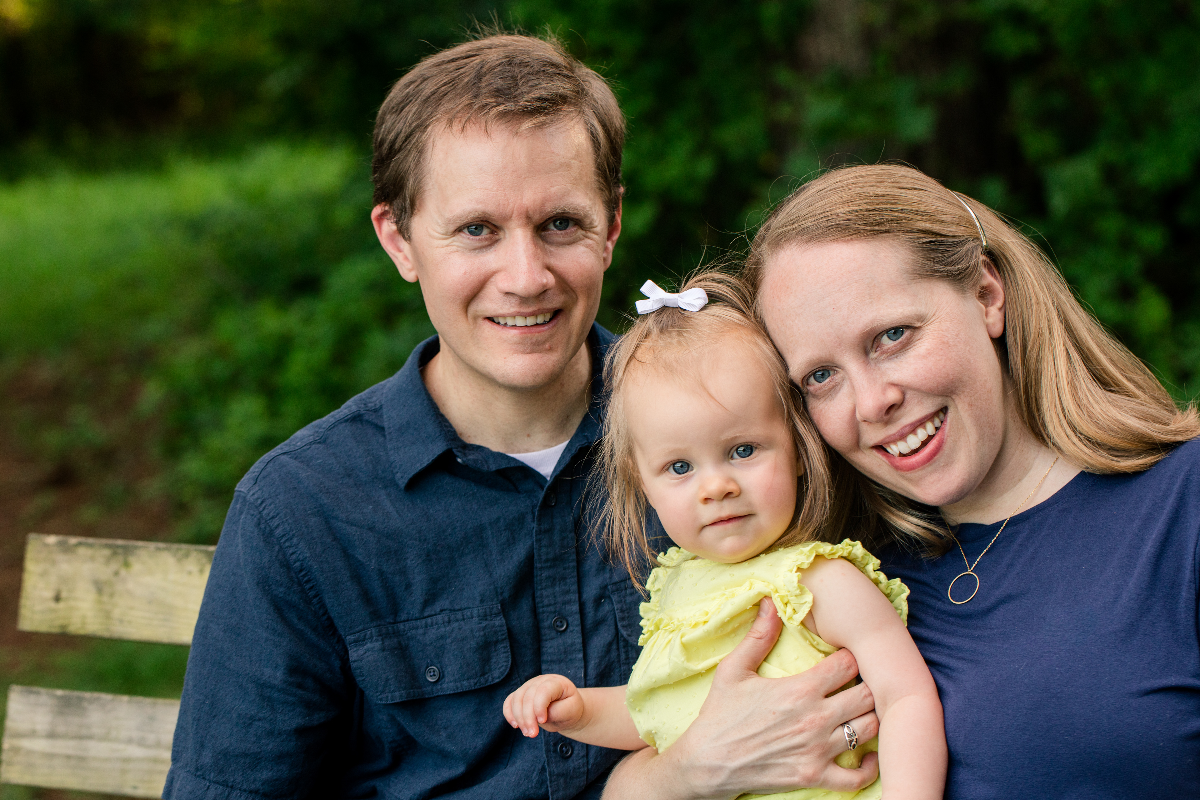 True color portrait of a family sitting on a bench.
