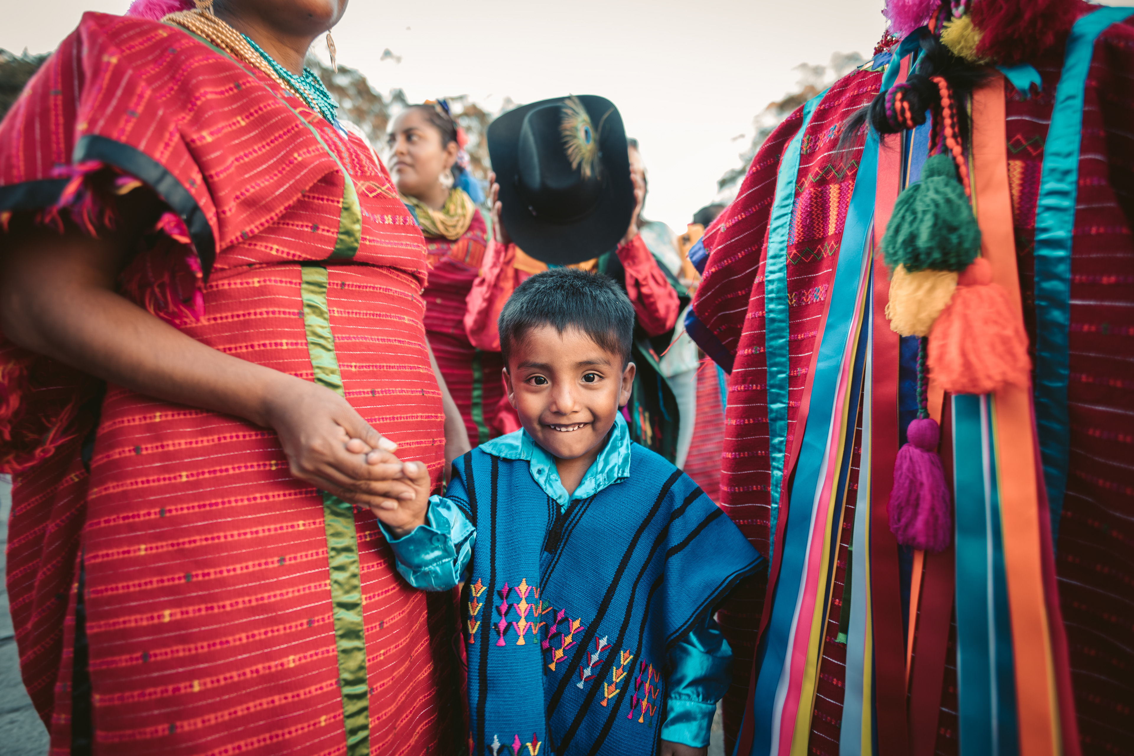 A boy and his women family members in a traditional parade in Oaxaca, Mexico