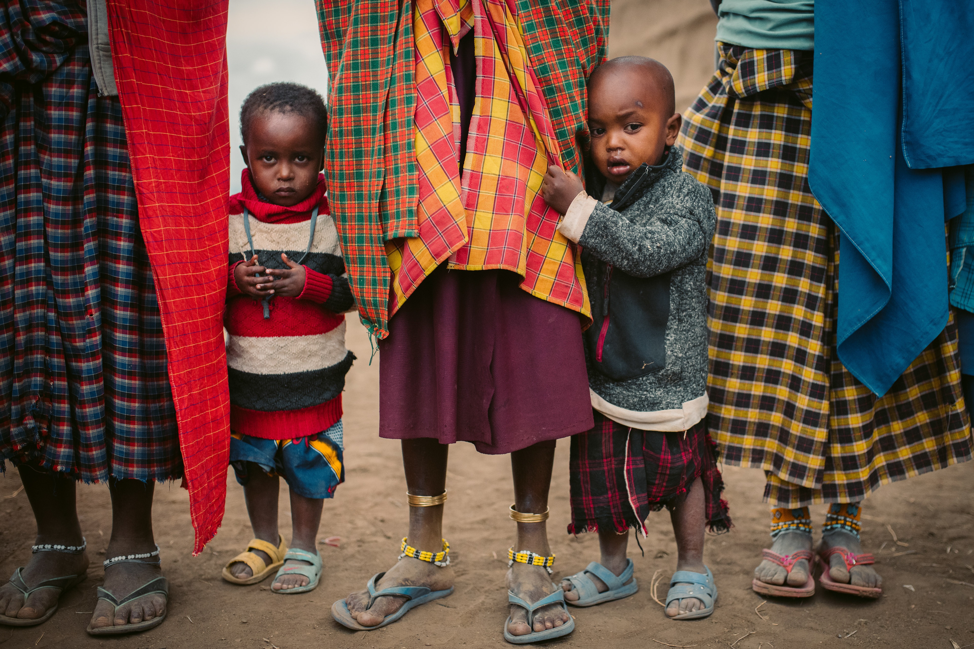 Two boys with their women caretakers in a Maasai village in Arusha, Tanzania