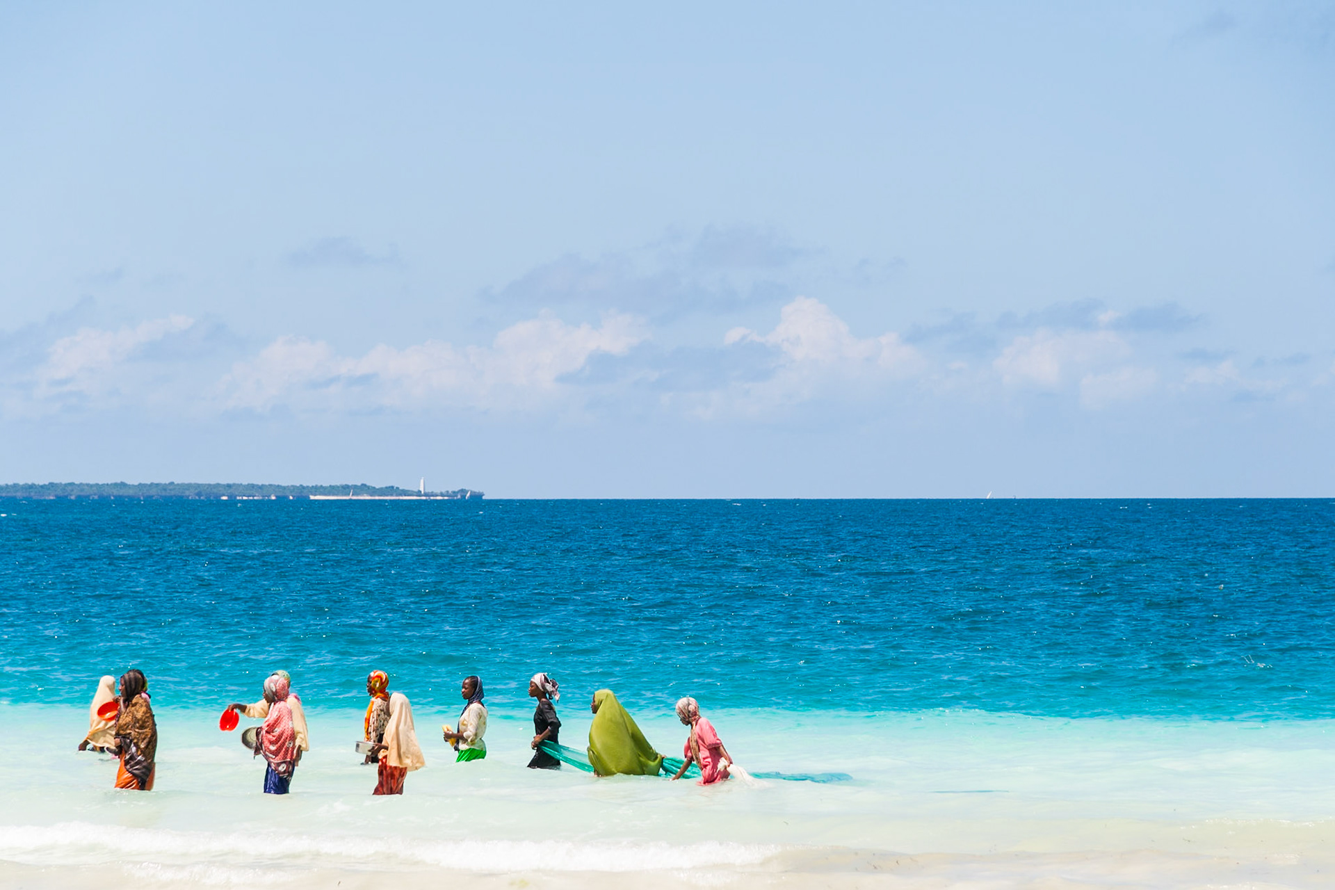Women in colourful clothes fishing in Tanzania.