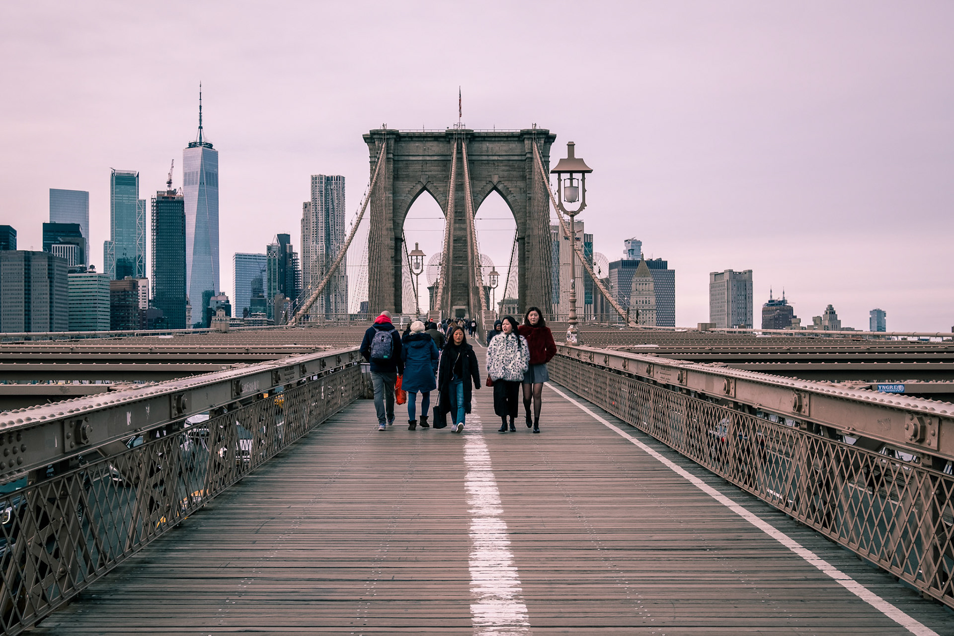People crossing the Brooklyn Bridge in New York City.