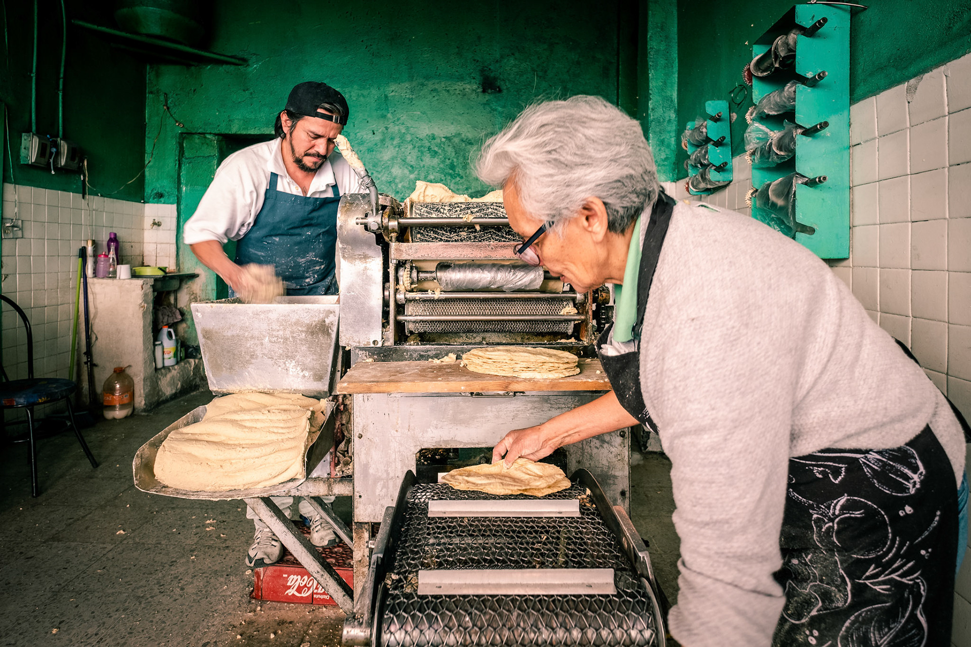 Workers producing corn tortillas in Tortilleria shop in Mexico City.