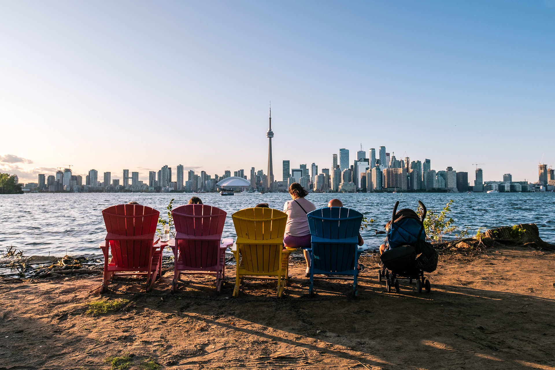 View of CN Tower and Toronto skyline from Toronto Islands Park at sunset.