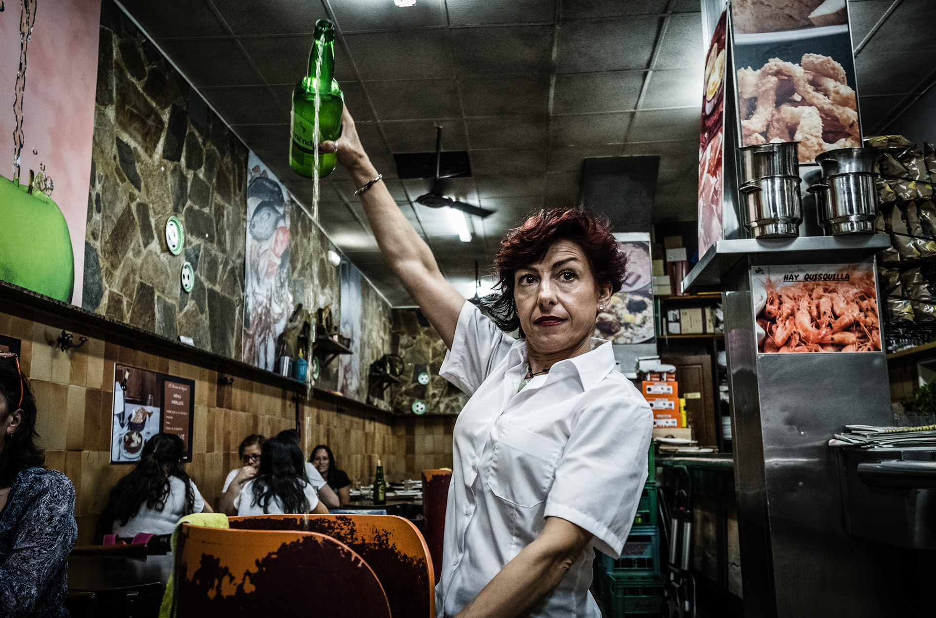 Waitress pouring Cider from a height, the most tipycal alcoholic beverage in Gijon, Asturias.