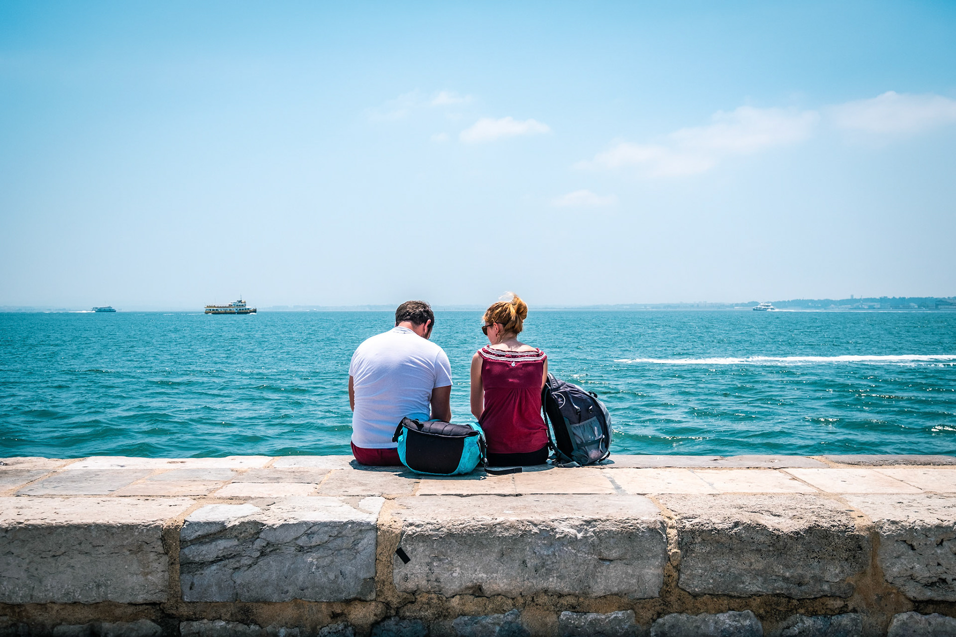 Young couple having a good time at the seashore in Lisbon, Portugal.