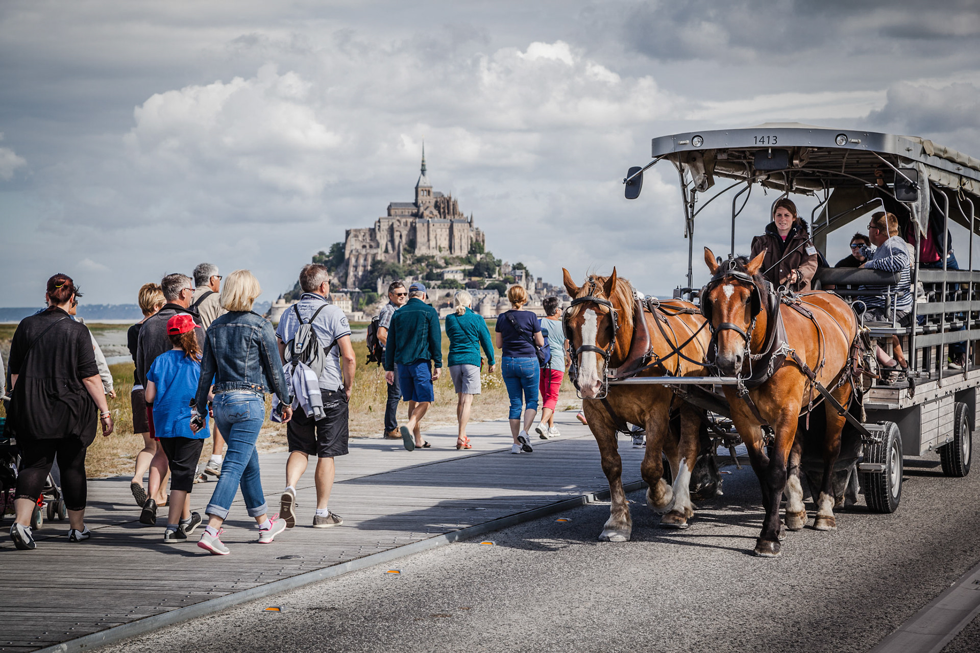 Tourists in a horse carriage near the Mont Saint Michel abbey