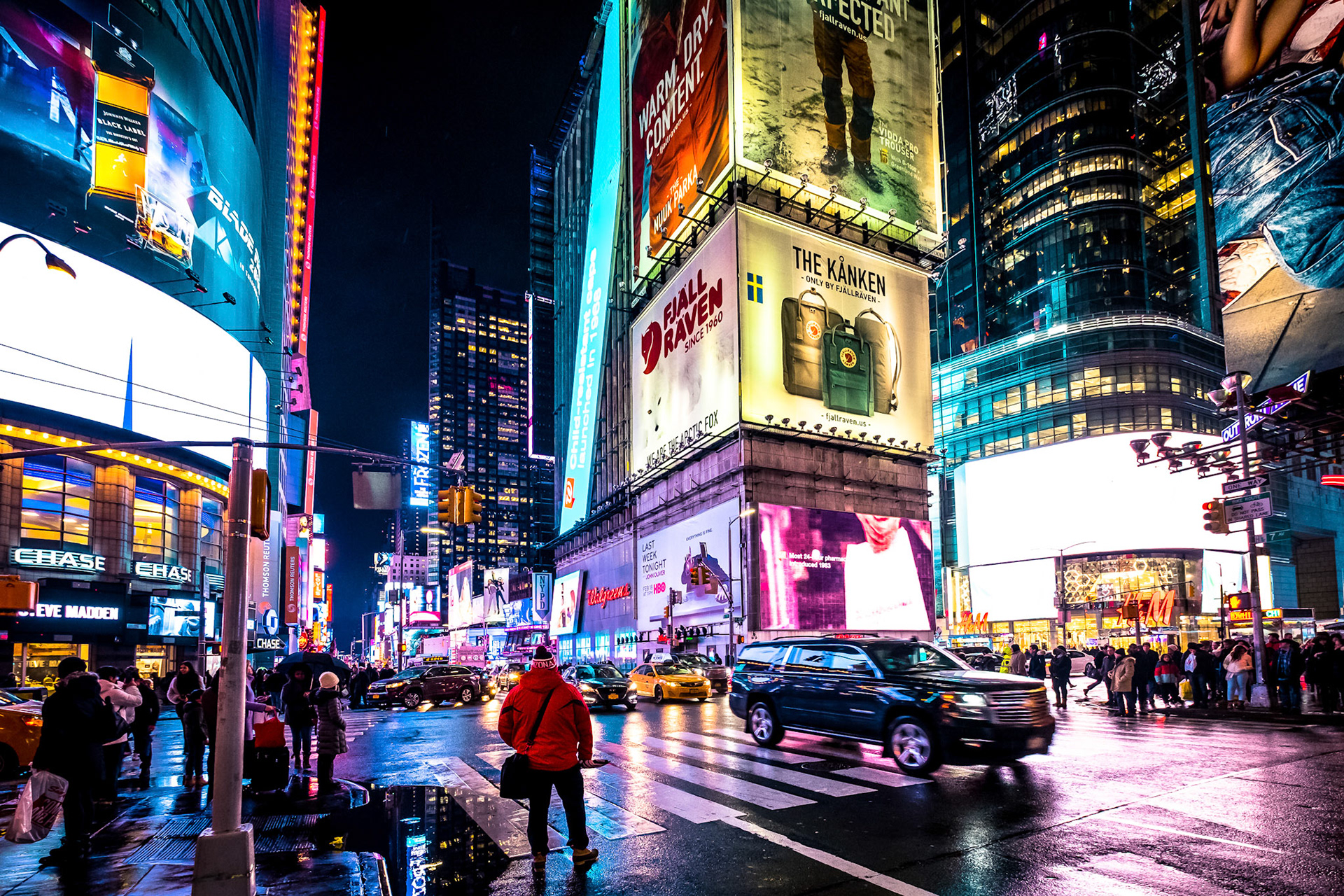 People walking in Times Square at night, midtown Manhattan, New York.