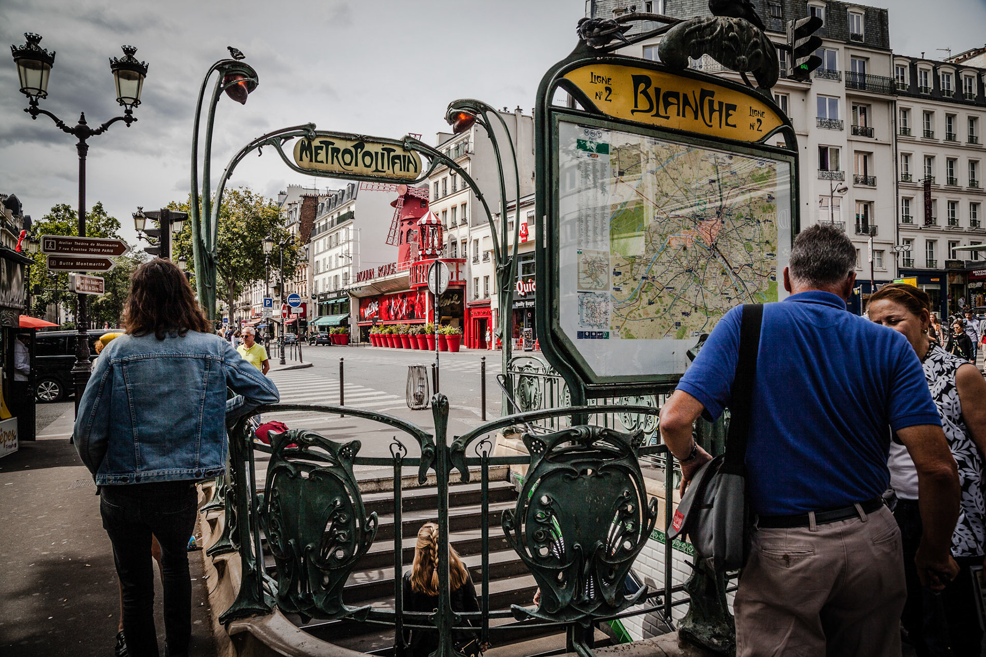 Paris Metro entrance with de Moulin Rouge in the back.