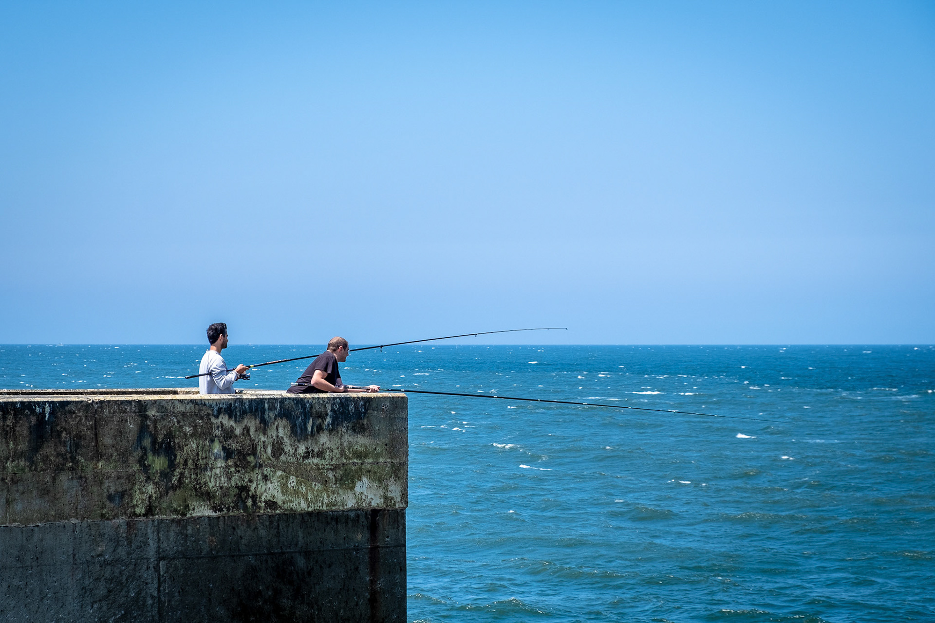 Guys fishing at Farolins da Barra do Douro. Porto. Portugal