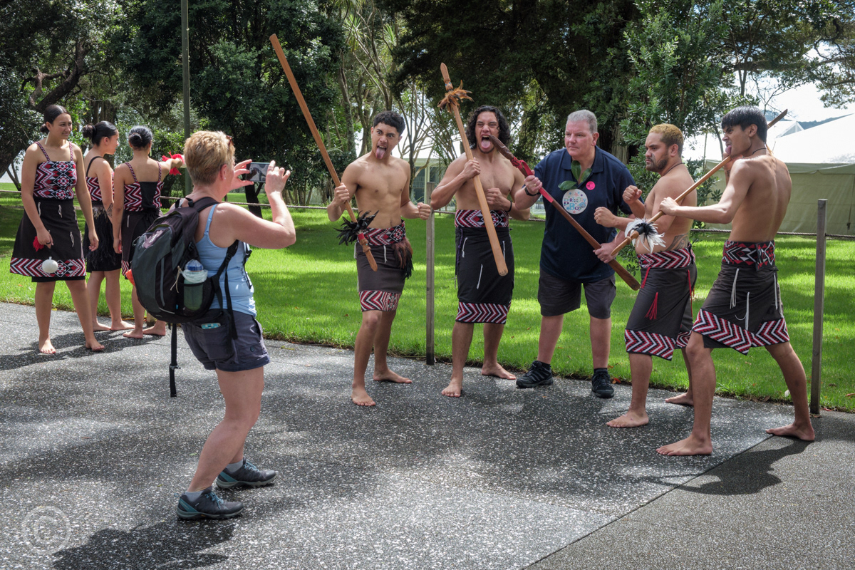 Tourists posing for a photograph with Maori performers at Waitangi Treaty Grounds