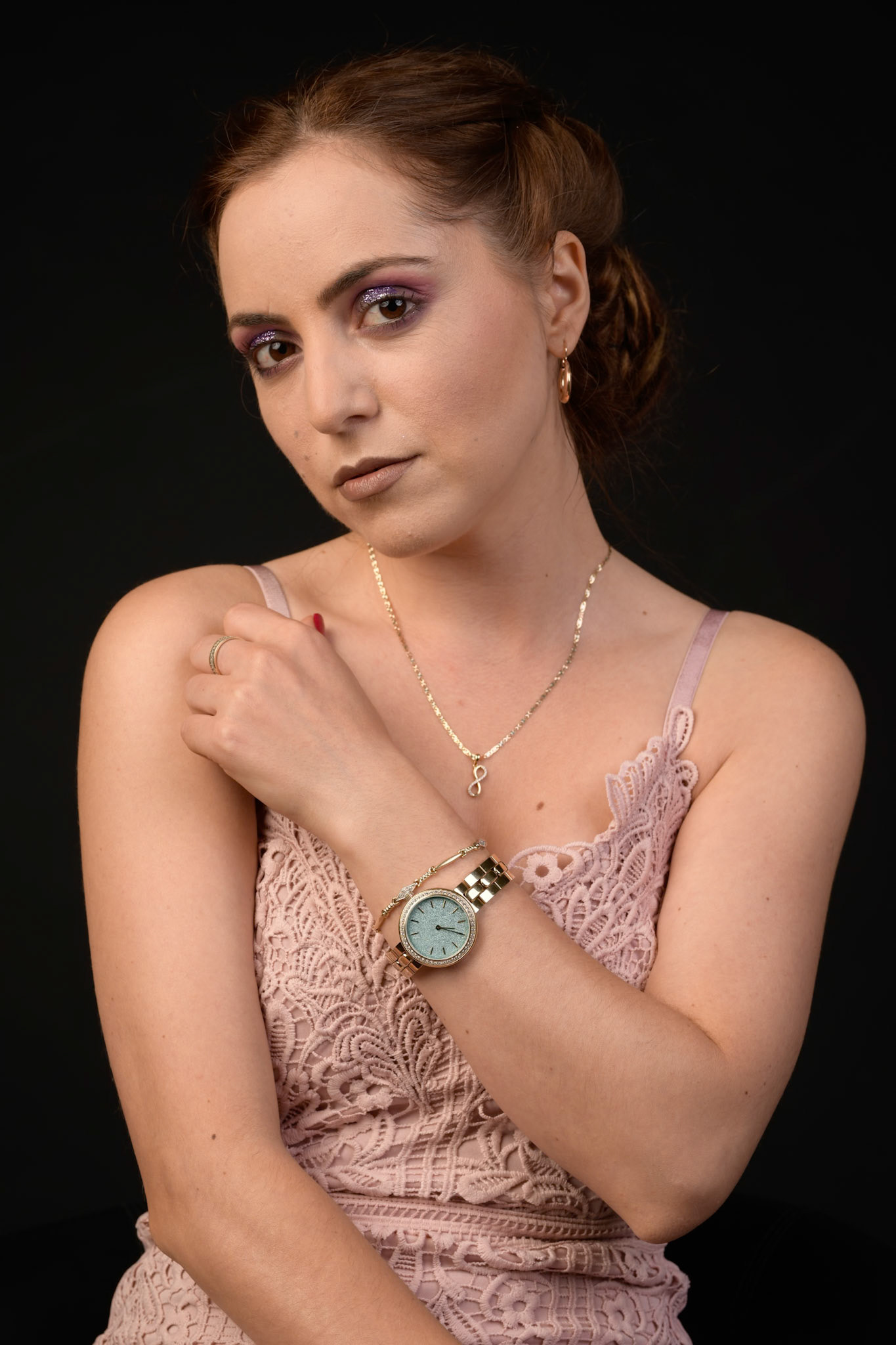 Half lenght portrait of a pretty young brunette woman against a black background.