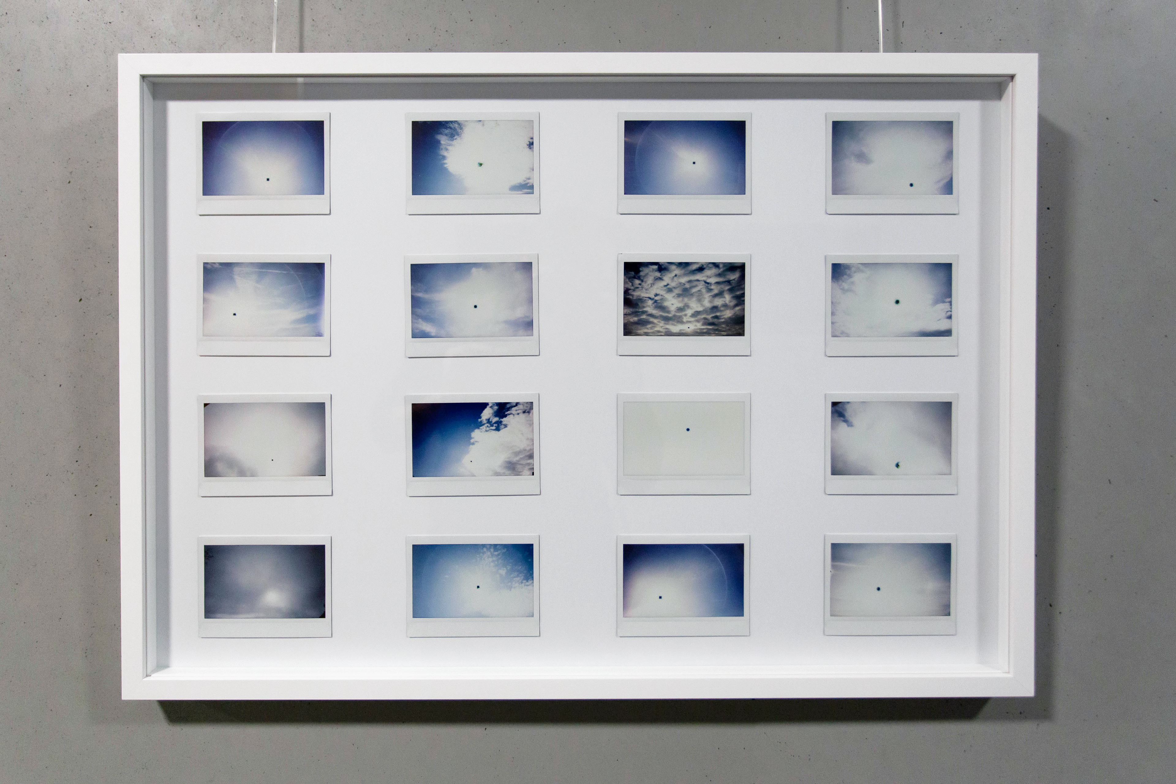 black sun polaroids clouds sky blue white picture frame art exhibition