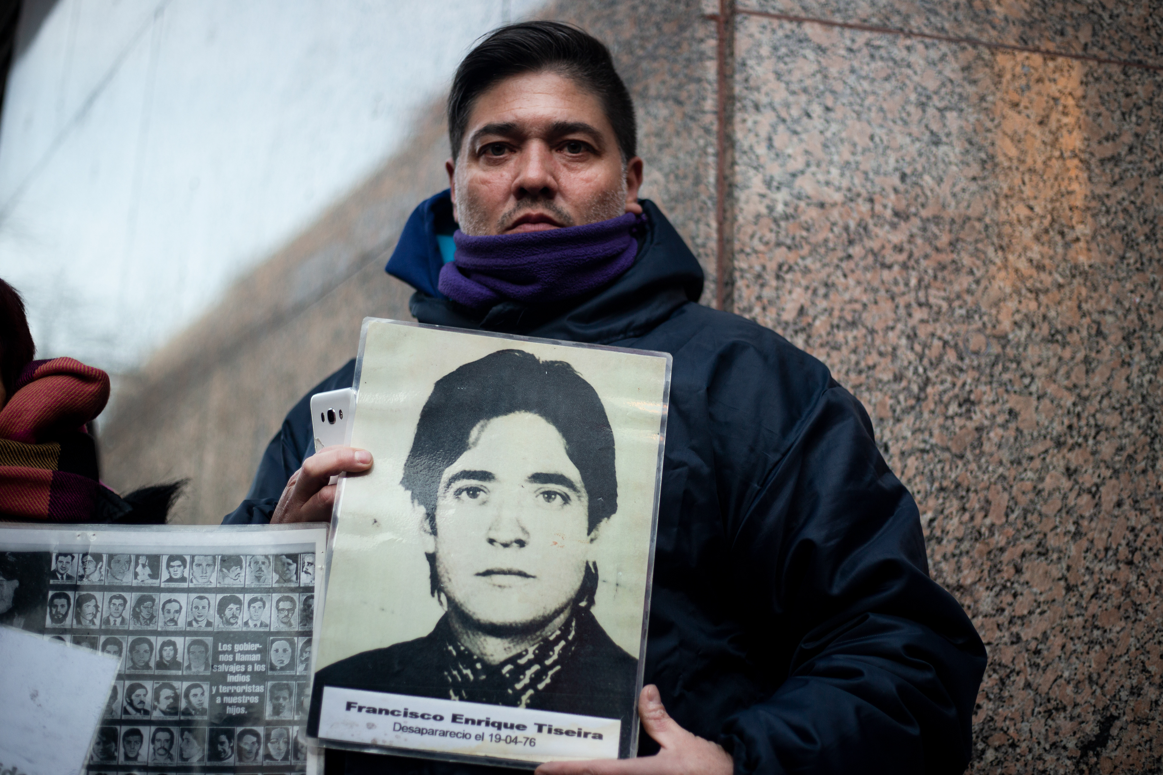 Un hombre hijo de Desaparecidos sostiene la fotografía de su padre en una manifestación en la Legislatura en contra de un acto en reivindicación a represores durante la última Dictadura cívico mílitar. Octubre 2023/ Regina Araujo. 